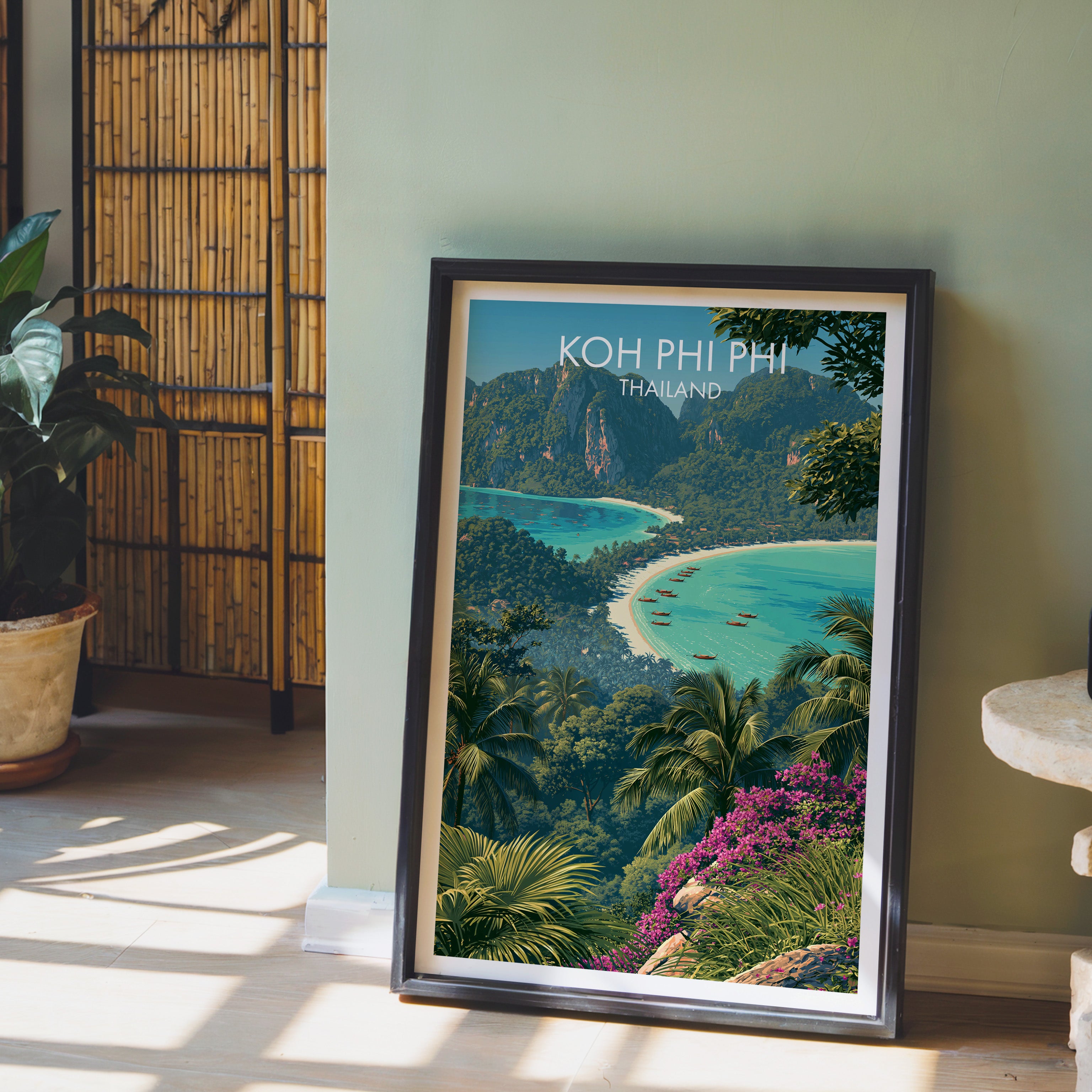 Koh Phi Phi Thailand wall art in a black frame leaning against a sage green wall beside a bamboo screen
