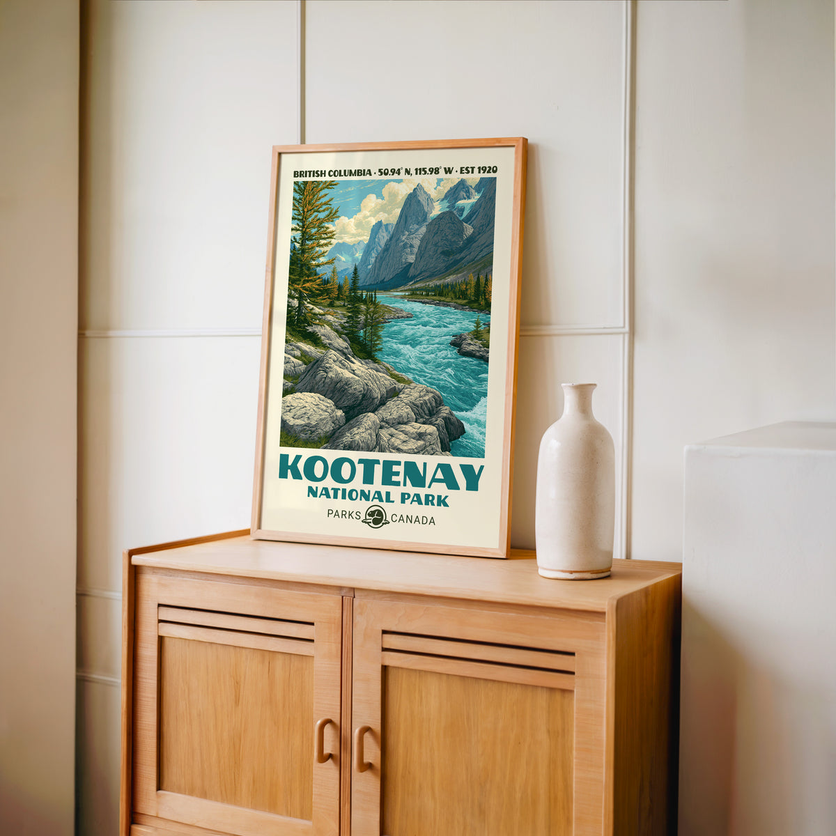 Kootenay larch valley wall art in an oak frame on a light wood cabinet beside a stoneware vase