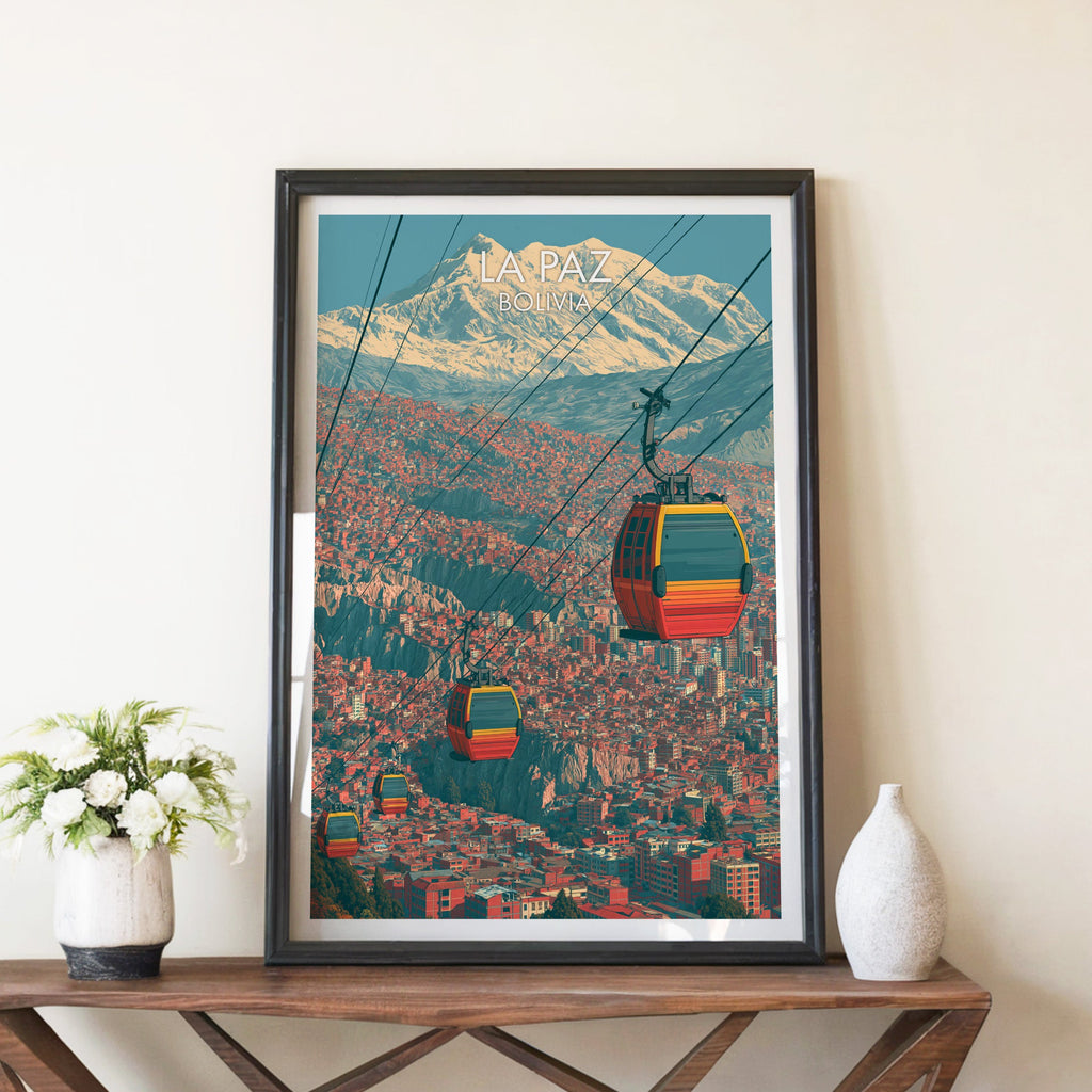 La Paz gondola poster in a black frame on a brown X-leg console with white blooms and a pale ceramic vase