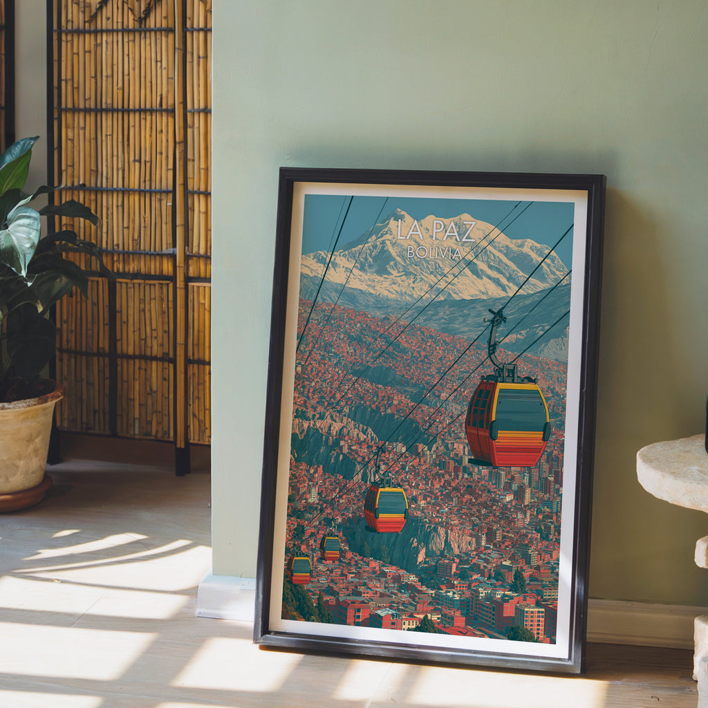 La Paz cityscape art in a dark brown frame on pale wood flooring by a sage green wall, bamboo screen and terracotta pot
