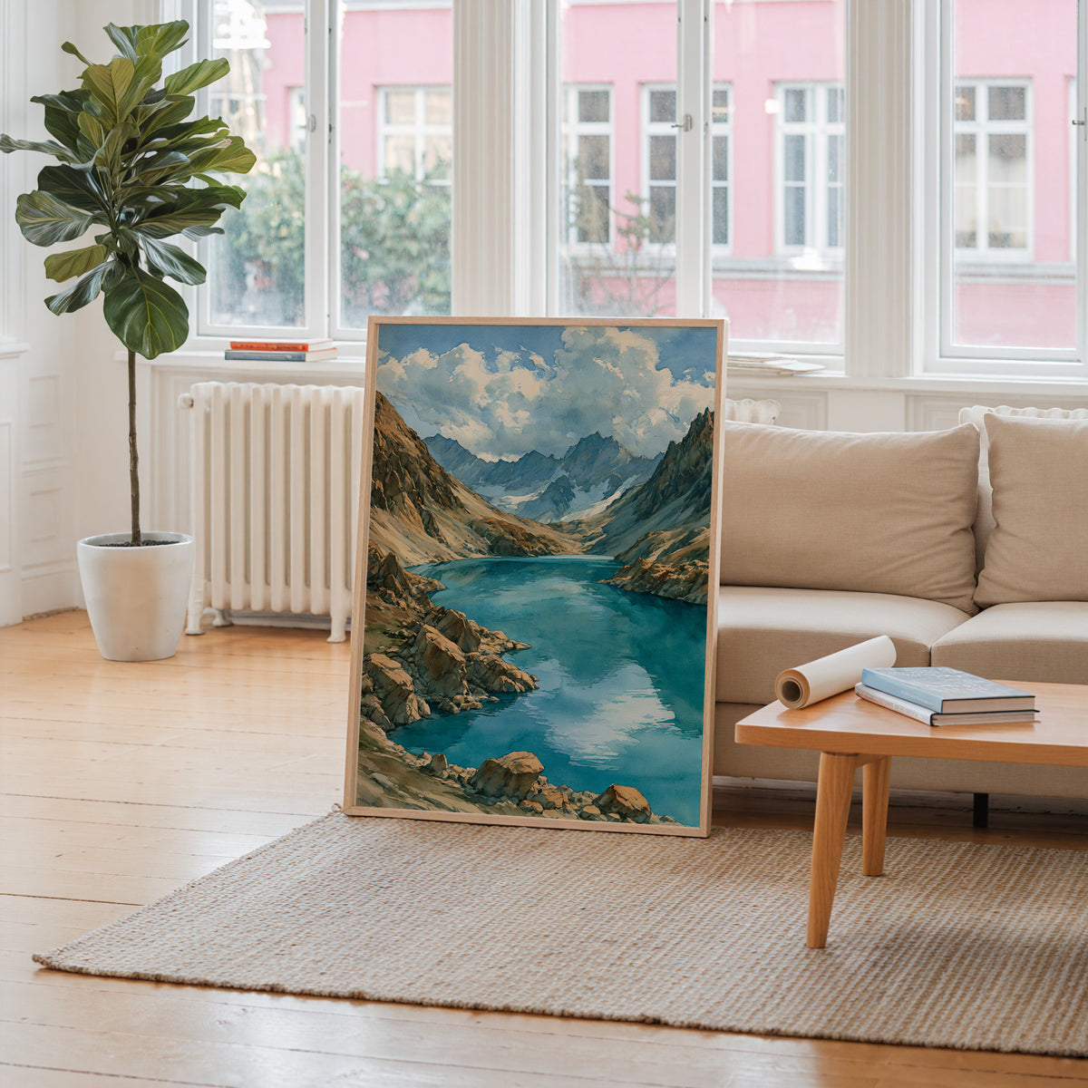 Lake Clark National Park watercolor art print leaning against a living room wall beside a linen sofa and coffee table