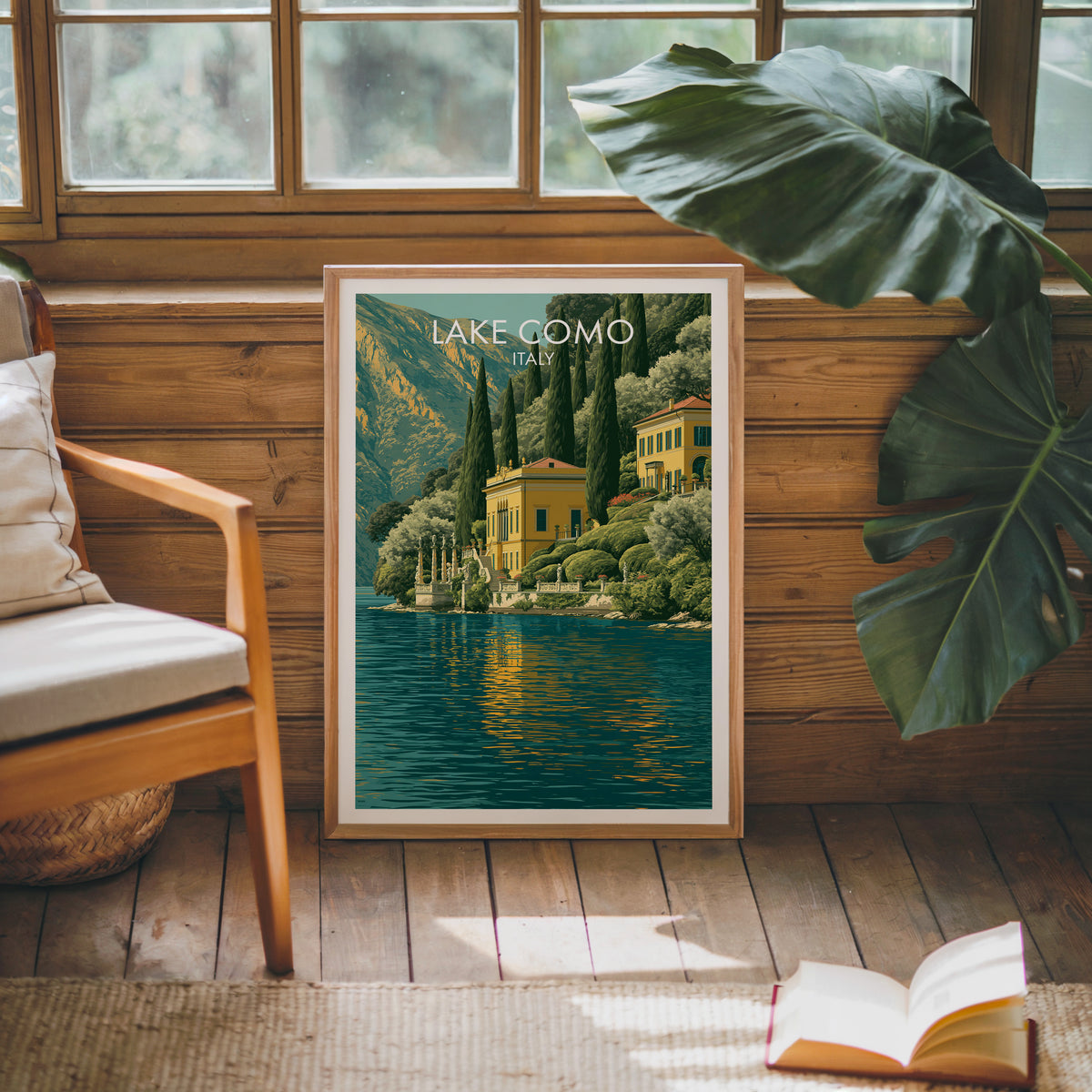 Lake Como villa print leaning on a wood panelled sunroom wall with a monstera and mid century armchair