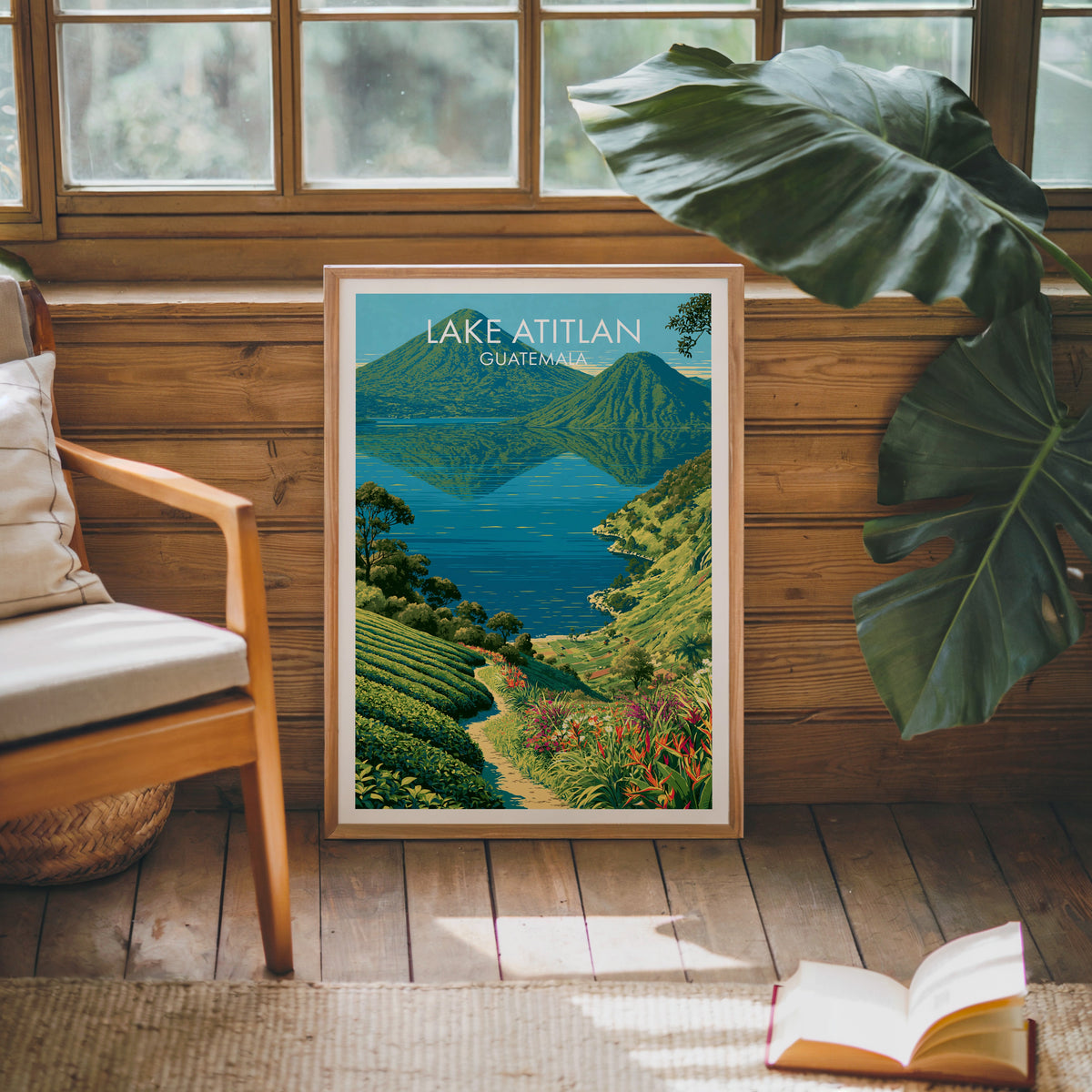 Lake Atitlan poster in an oak frame leaning on a pine cabin wall, wooden armchair, monstera leaf and a jute rug