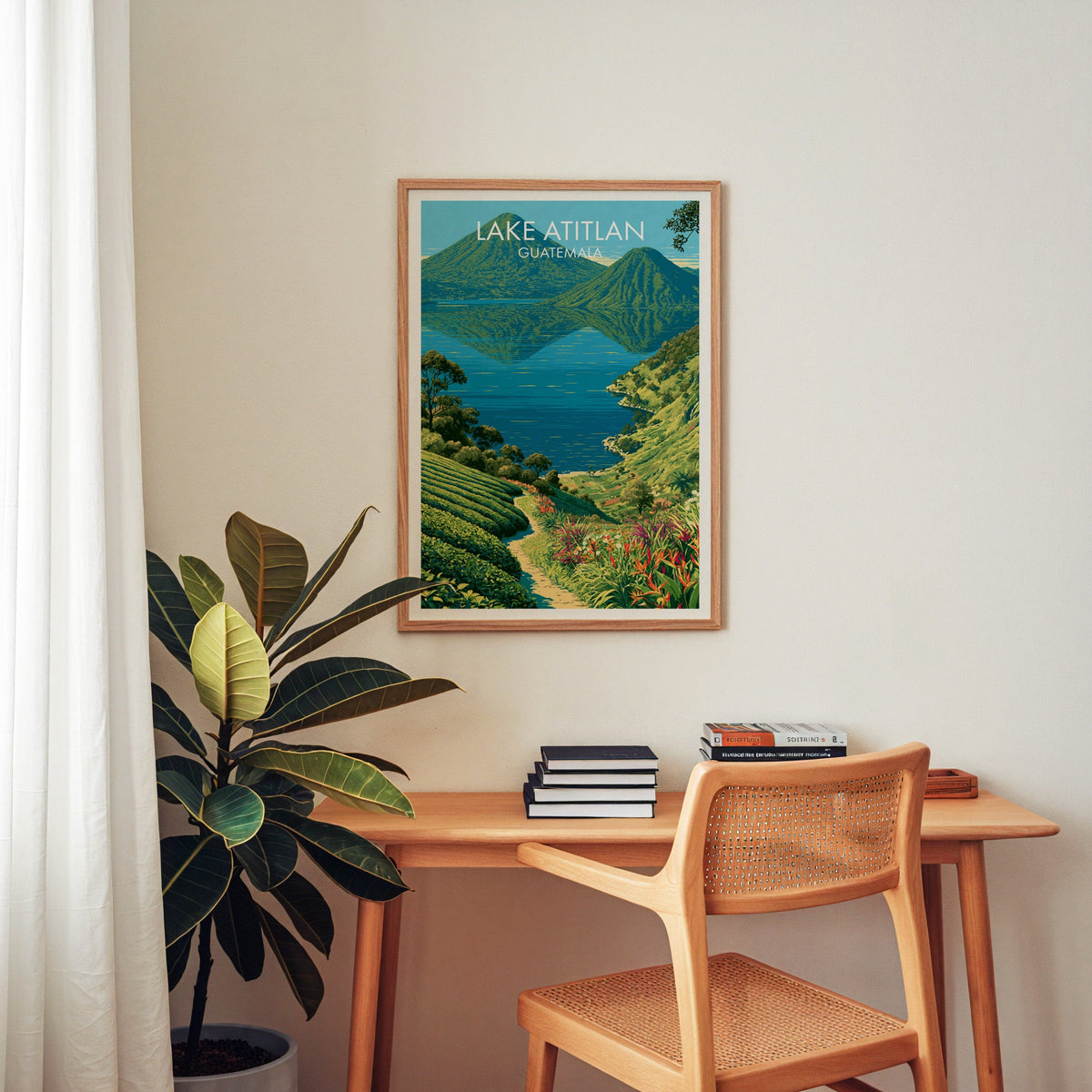 Central America travel print in an oak frame above a wooden home-office desk with a cane chair and rubber plant