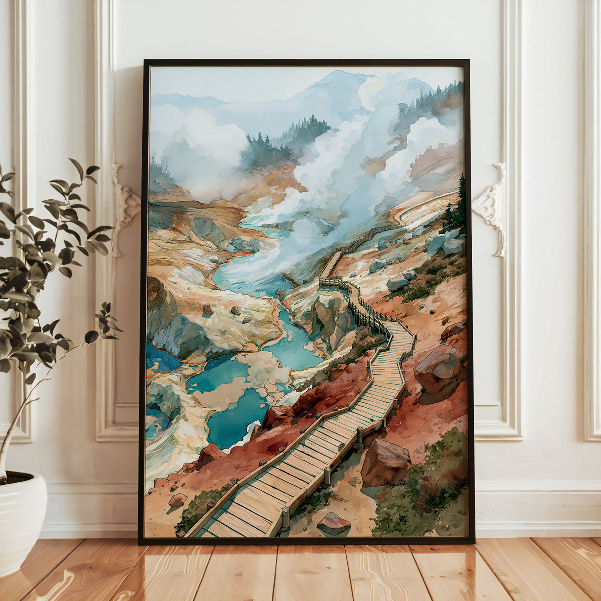 Lassen Volcanic National Park watercolor print in a black frame leaning against a white paneled wall beside a potted plant