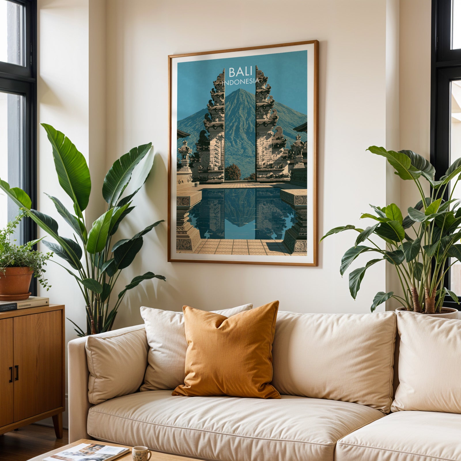 Framed Lempuyang Temple Bali Indonesia wall art hanging above a cream sofa in a bright living room with tropical plants