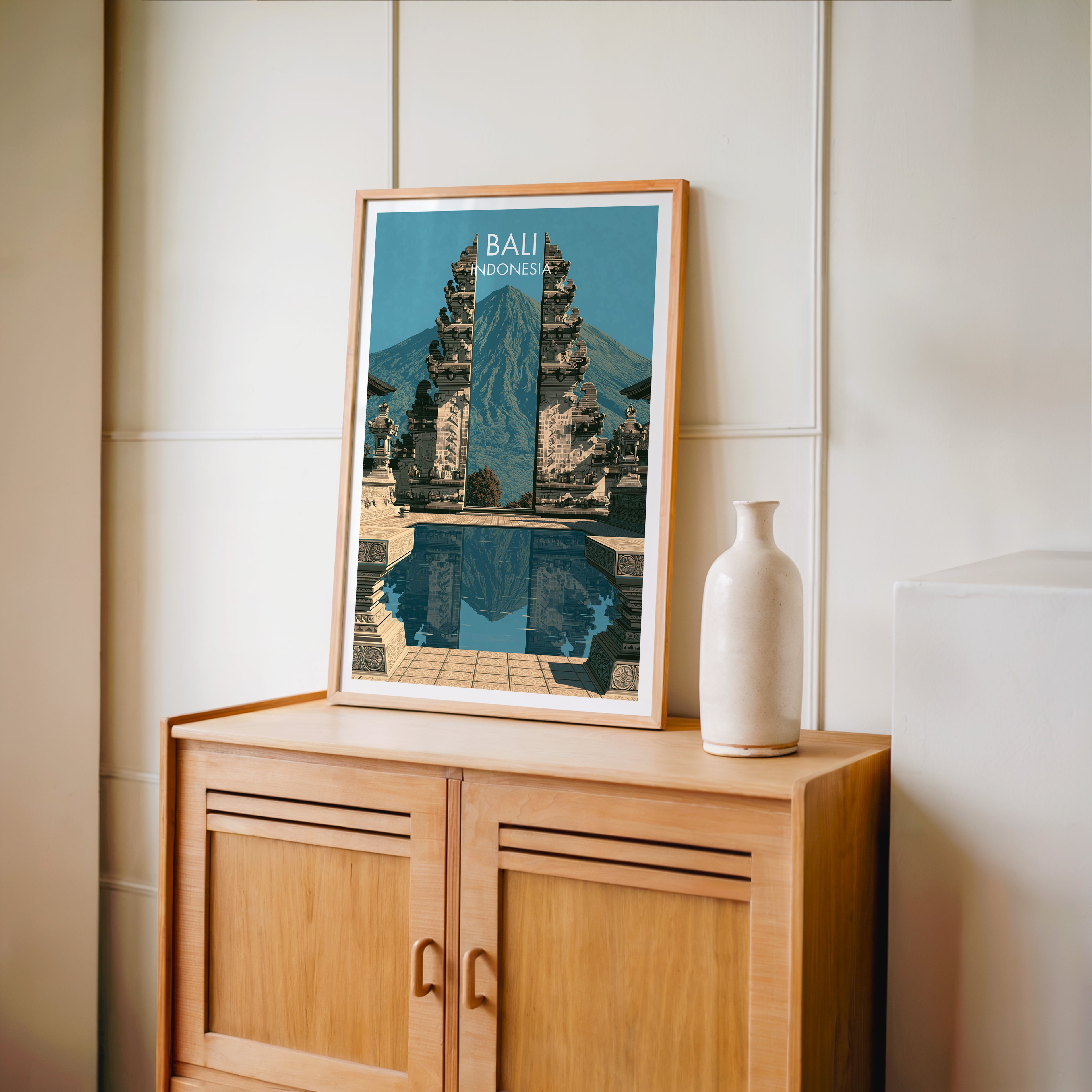 Small Lempuyang Temple Bali Indonesia travel poster in an oak frame on a mid-century sideboard with a ceramic vase