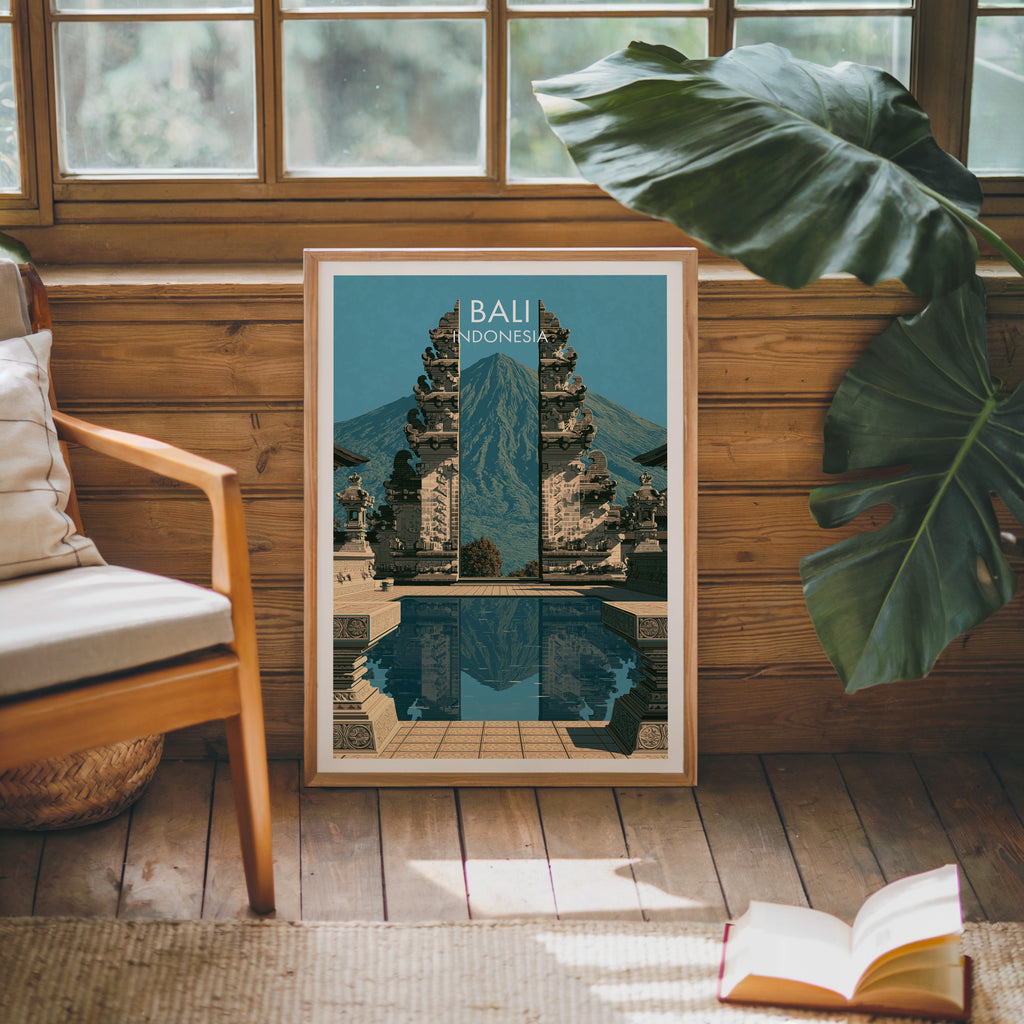 Framed Lempuyang Temple Bali Indonesia poster leaning against a timber cabin wall with monstera leaves and an open book