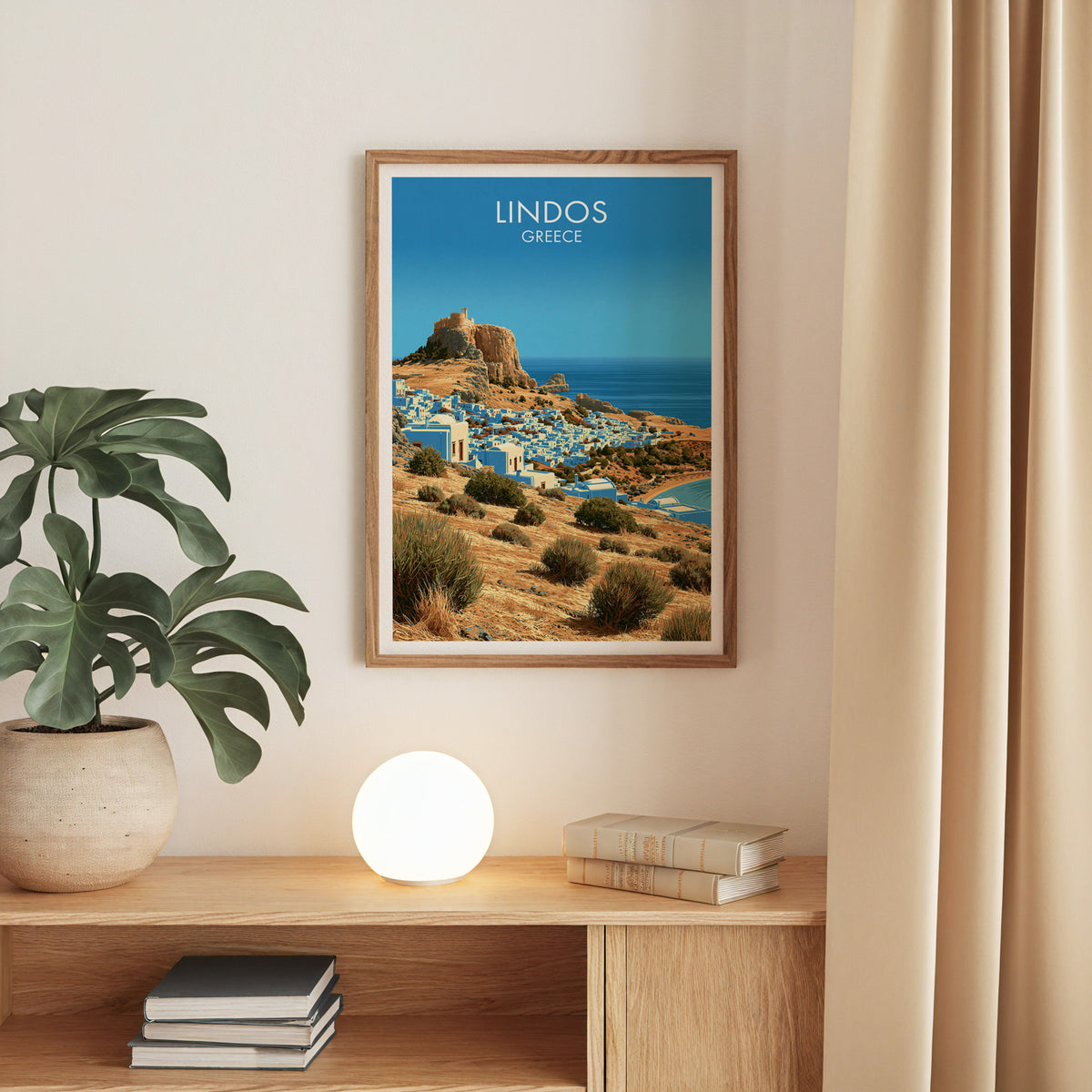 Lindos whitewashed village print, oak frame above an oak console with a monstera and a round globe lamp