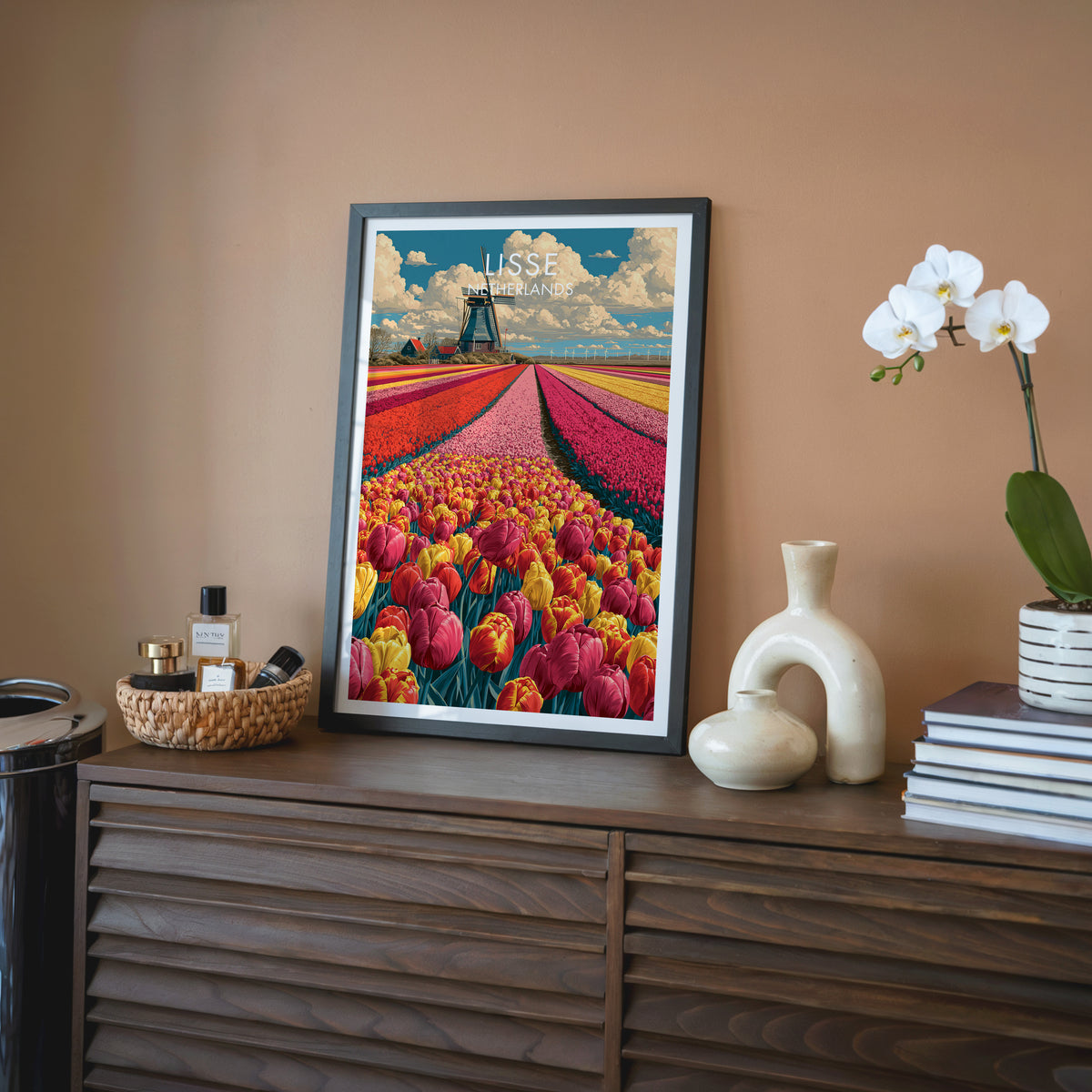 Lisse travel wall art in a black frame on a walnut sideboard against a terracotta wall, beside an orchid