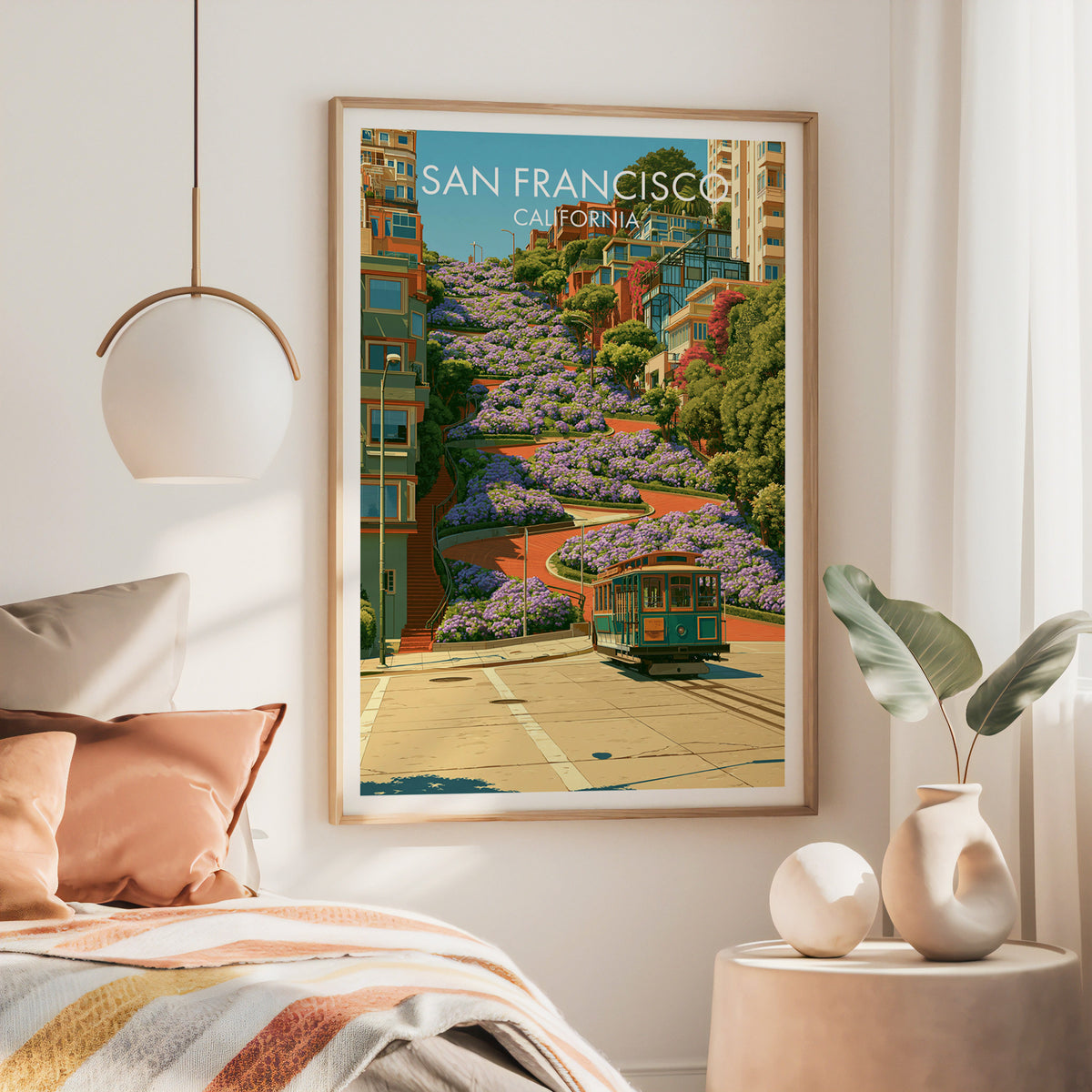 Large oak framed Lombard Street poster above a bed with rust bedding and a brass pendant lamp