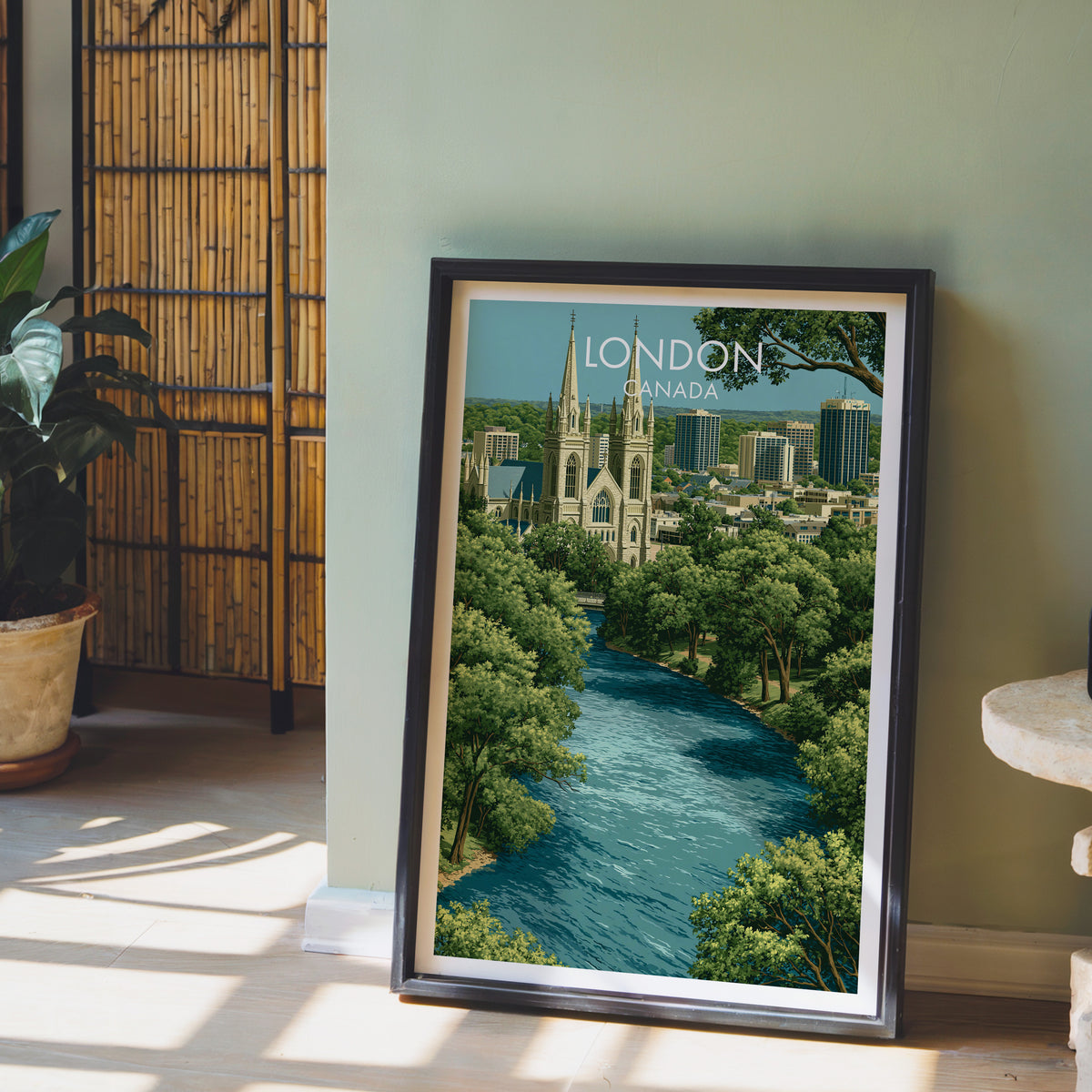 London Ontario travel print in a black frame on the floor by a sage wall and bamboo screen