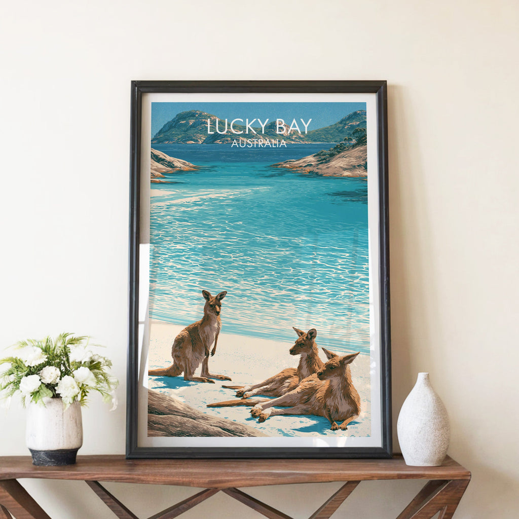 Kangaroos on the beach print in a black frame on a walnut console with white peonies and a stone vase