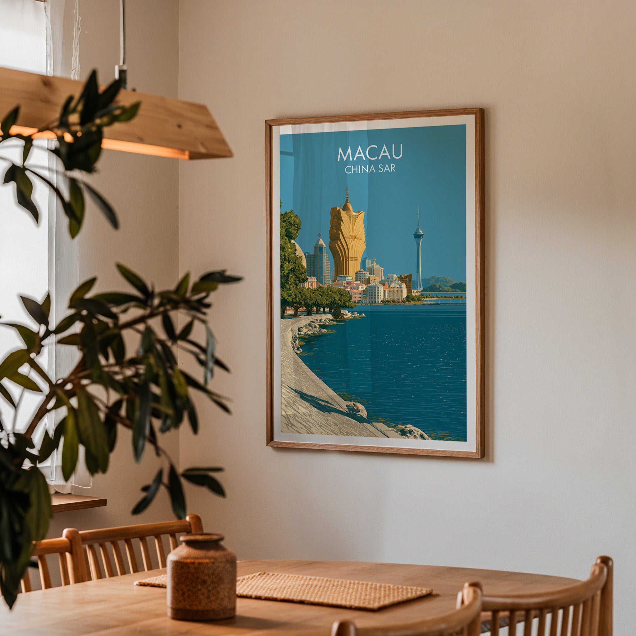 Framed Macau China print on a dining room wall above an oak table in warm afternoon light