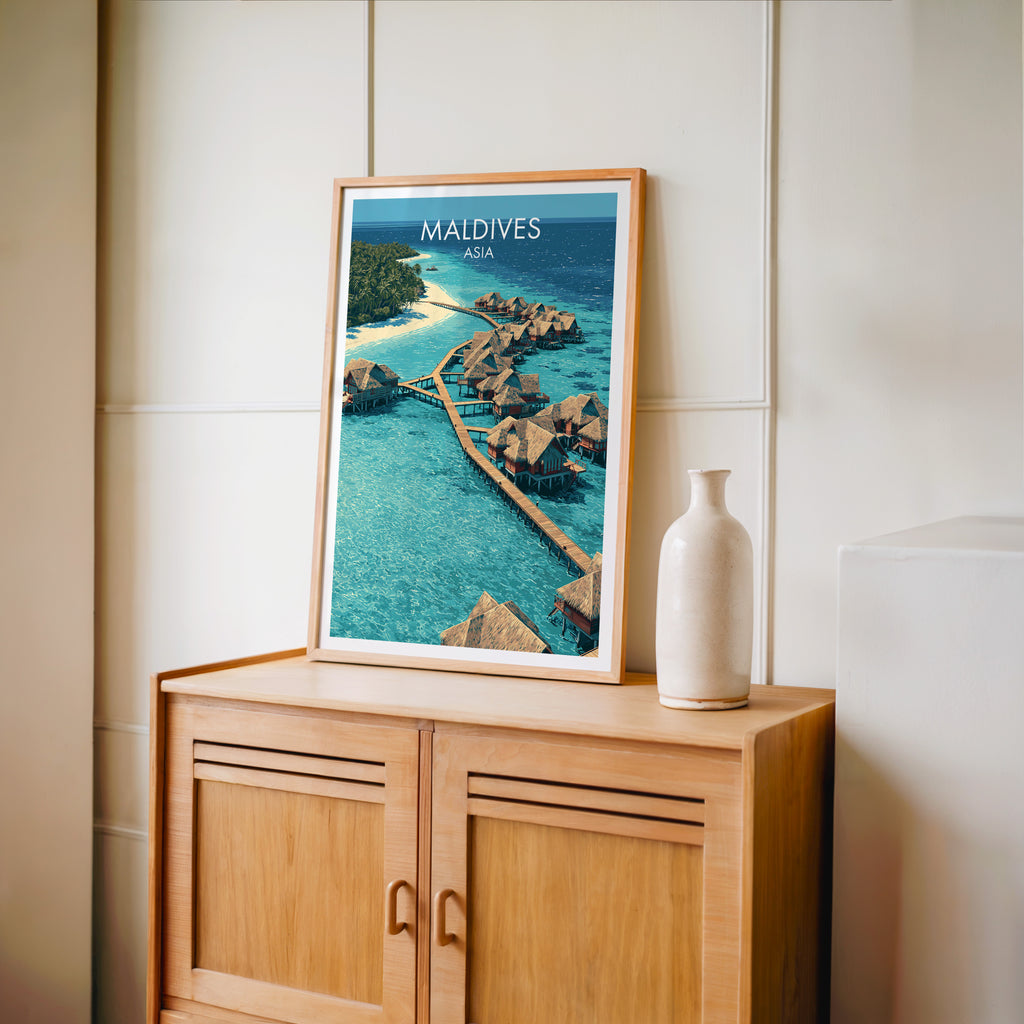 Small Maldives travel poster in an oak frame on a mid-century sideboard with a ceramic vase
