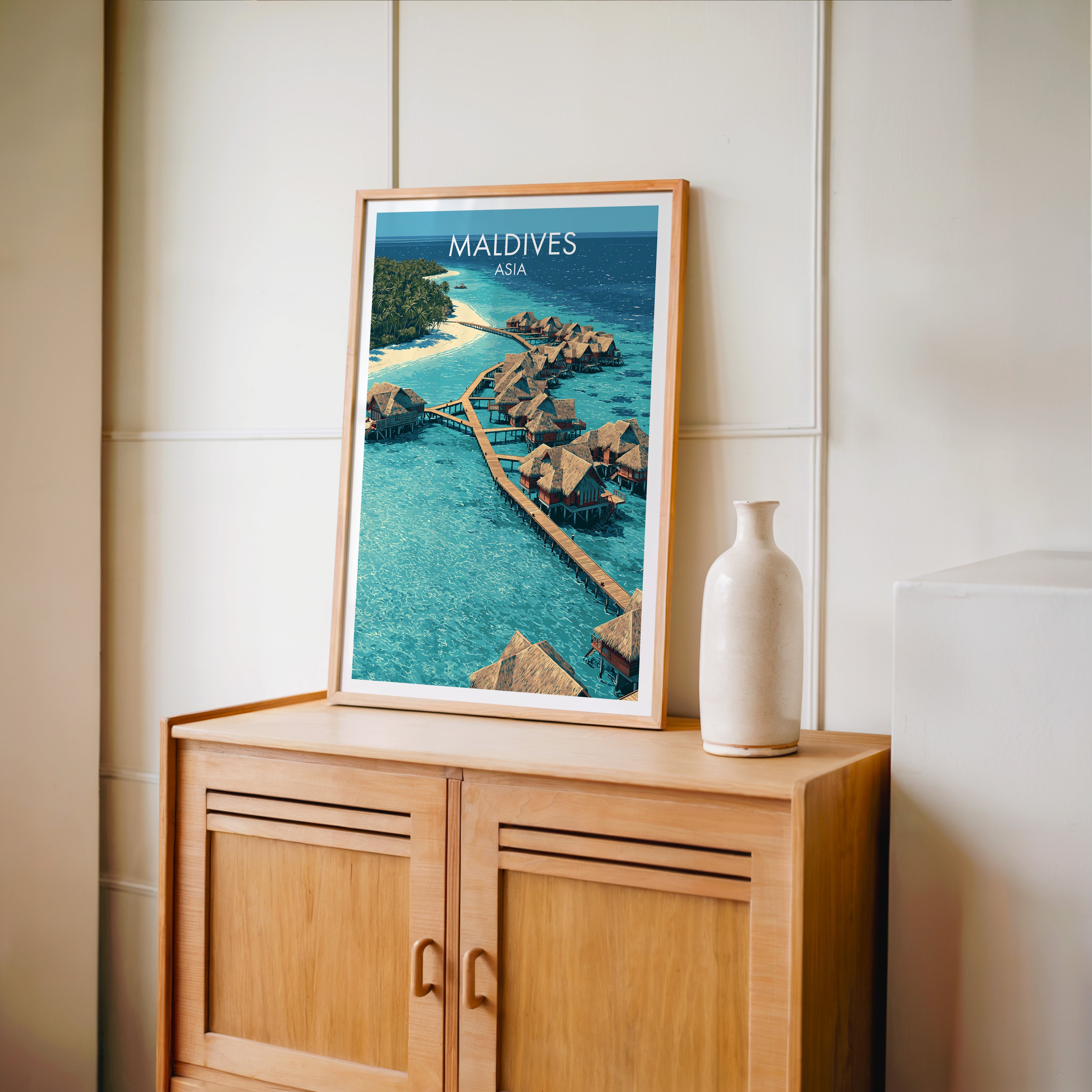 Small Maldives travel poster in an oak frame on a mid-century sideboard with a ceramic vase