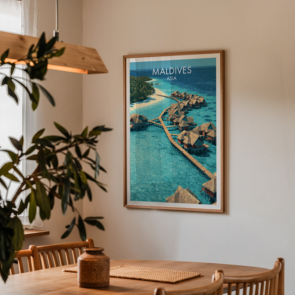 Framed Maldives print on a dining room wall above an oak table in warm afternoon light
