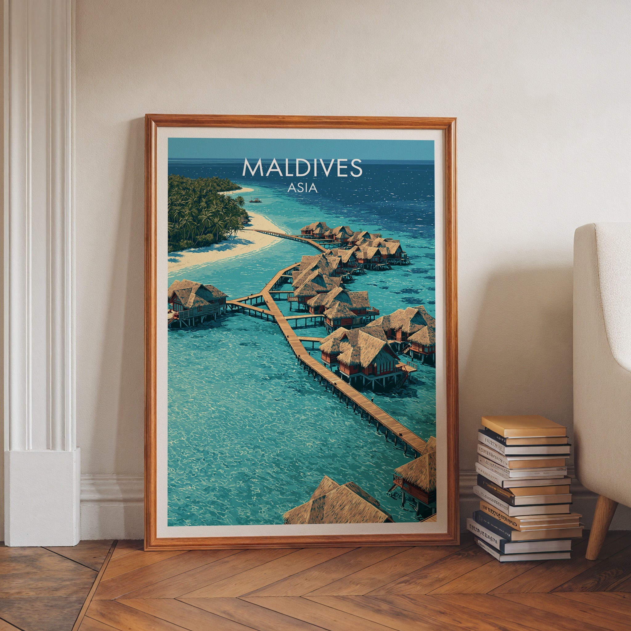 Maldives art print in a walnut frame leaning in a hallway beside stacked books