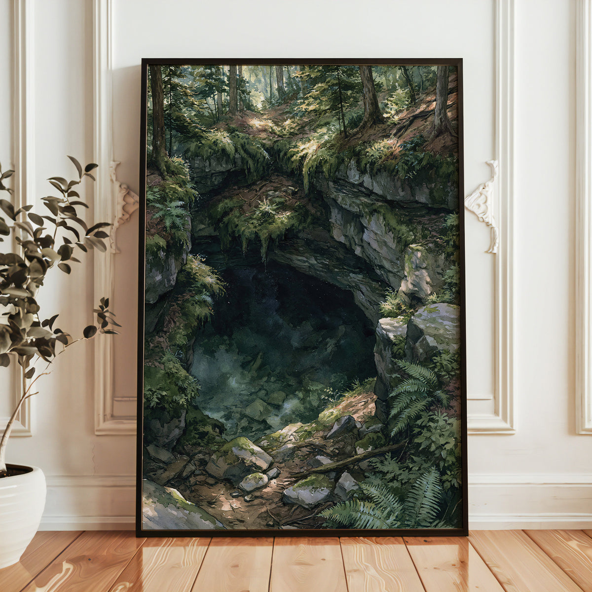 Mammoth Cave National Park watercolor print in a black frame leaning against a white paneled wall beside a potted plant