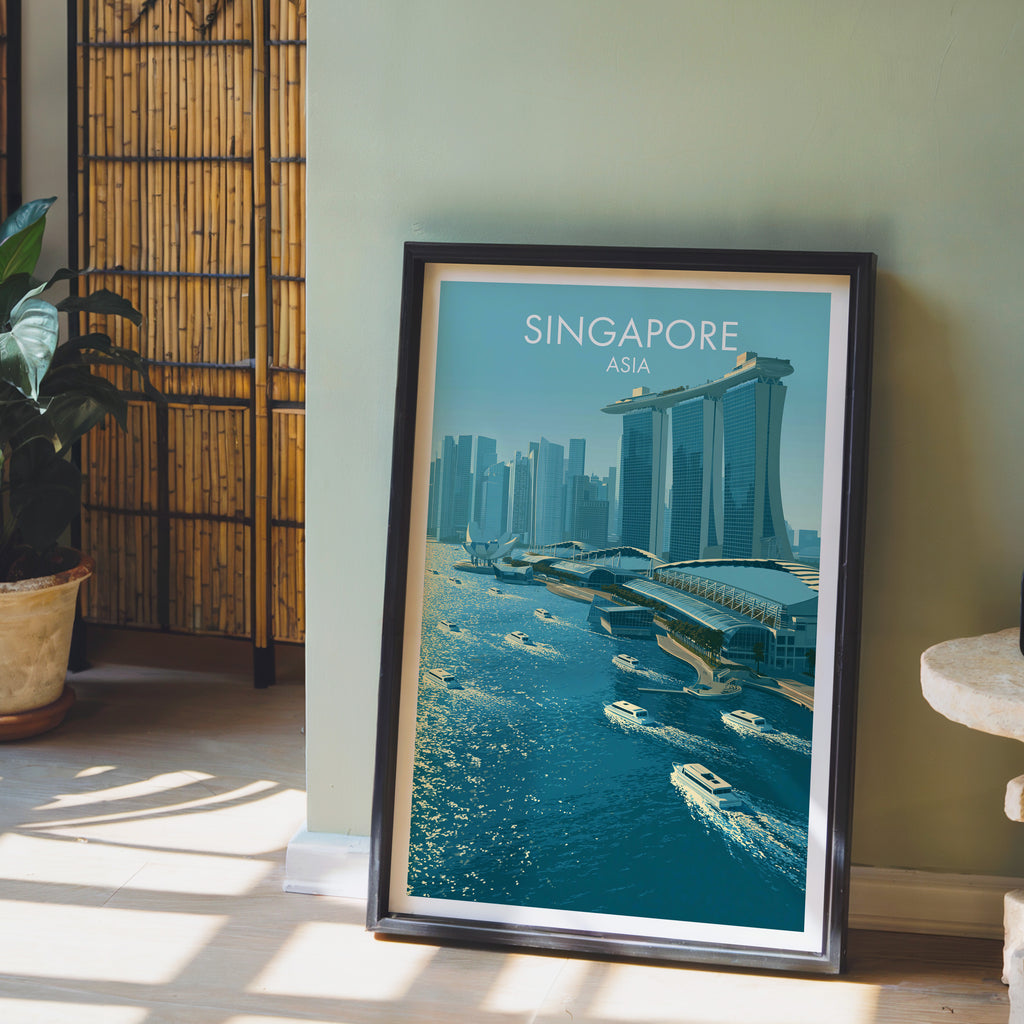 Marina Bay Sands Singapore wall art in a black frame leaning against a sage green wall beside a bamboo screen