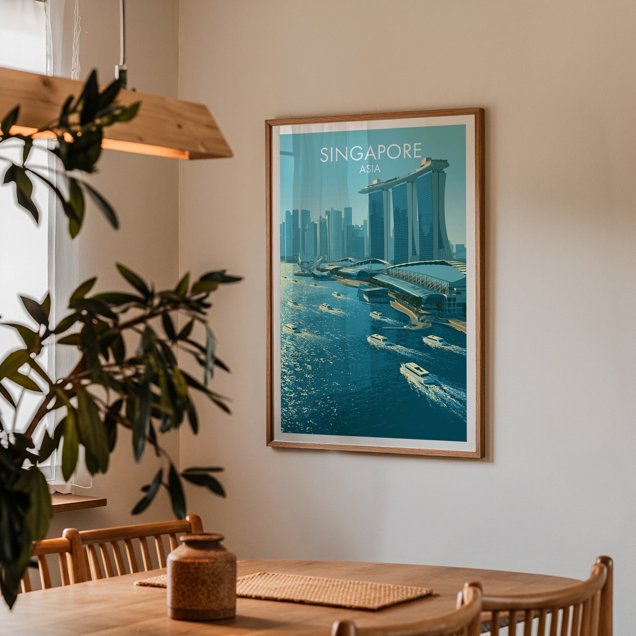 Framed Marina Bay Sands Singapore print on a dining room wall above an oak table in warm afternoon light