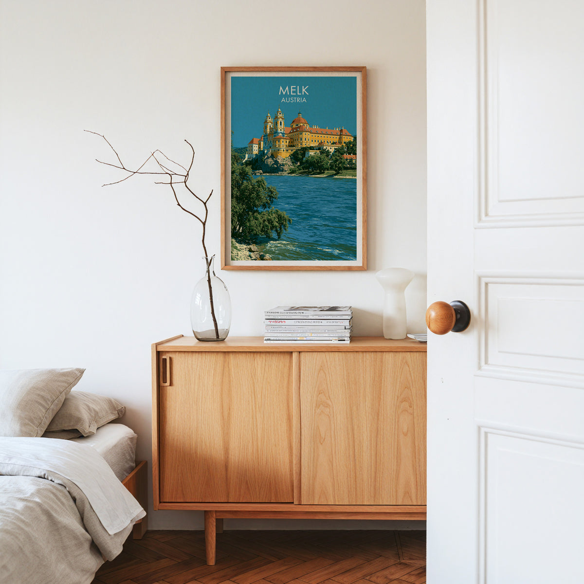 Melk Abbey baroque print, oak frame above a light oak sideboard with bare branches in a glass vase