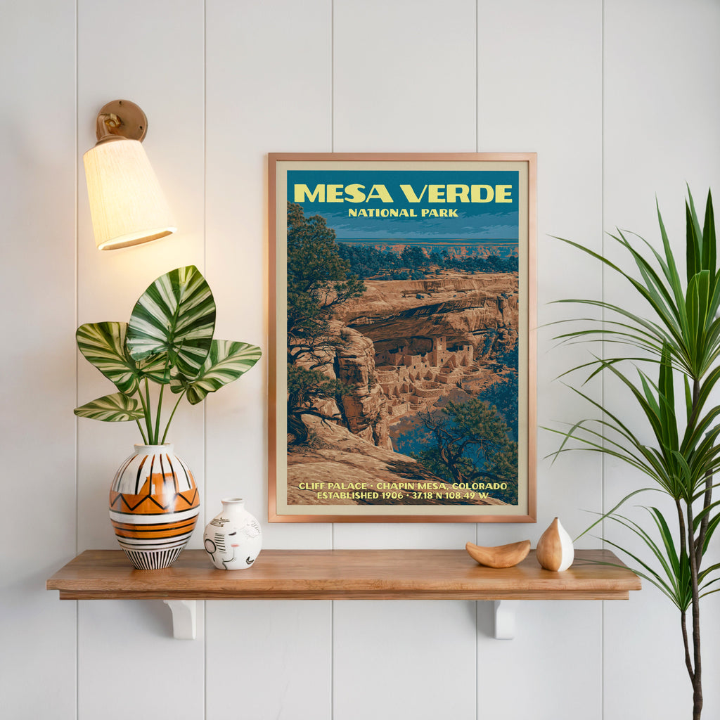 Cliff Palace Mesa Verde print framed on white panelling above an oak shelf with a patterned vase and brass sconce