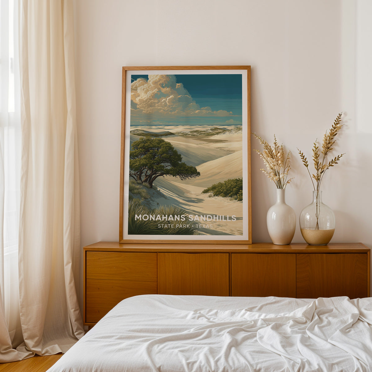 West Texas dune print in oak on a teak sideboard by a bed with dried pampas in two white vases