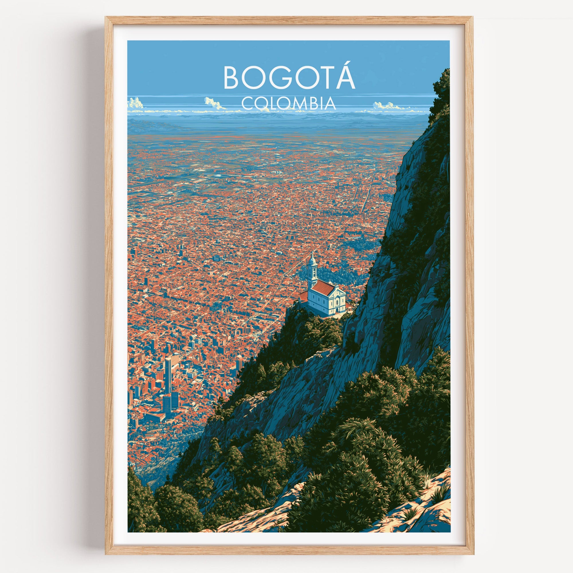 Monserrate Bogota travel print of the white hilltop church above the city in a light oak frame on a white wall