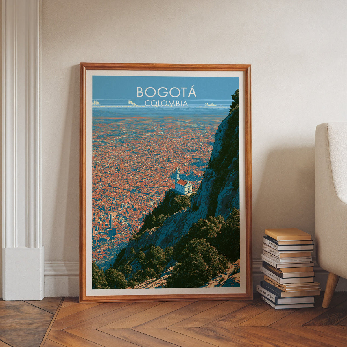 Bogota skyline print in a walnut frame on a herringbone floor by white wall moulding, book stacks and an armchair