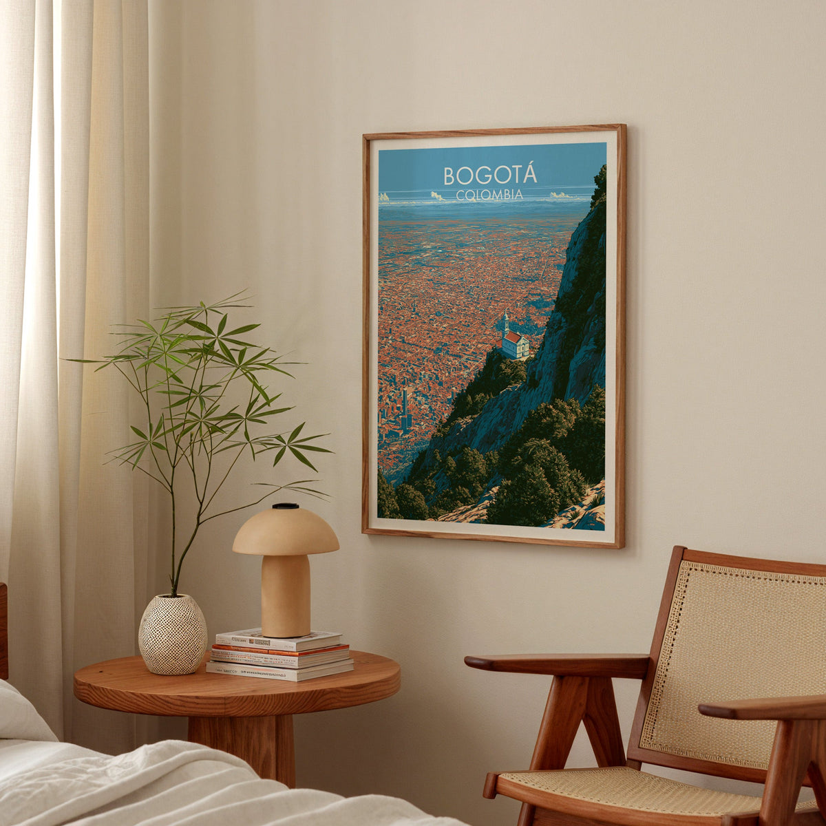 White church on a cliff wall art in a walnut frame in a bedroom above a round nightstand with a terracotta lamp