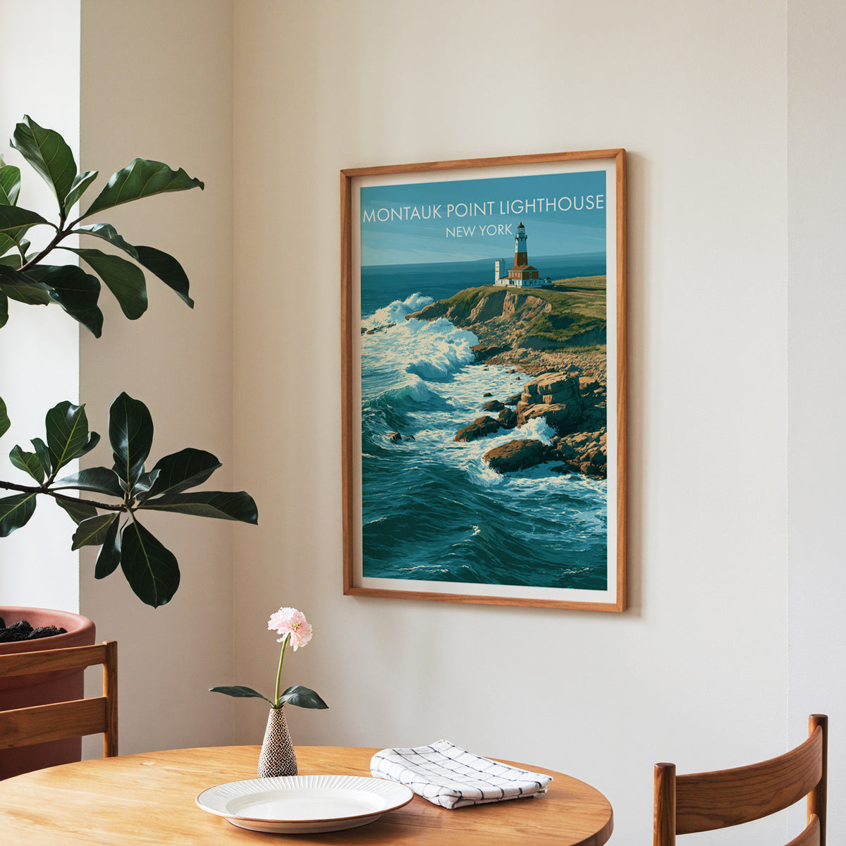 Montauk Point Lighthouse art in a walnut frame in a dining corner with a round table, checked cloth and fig tree