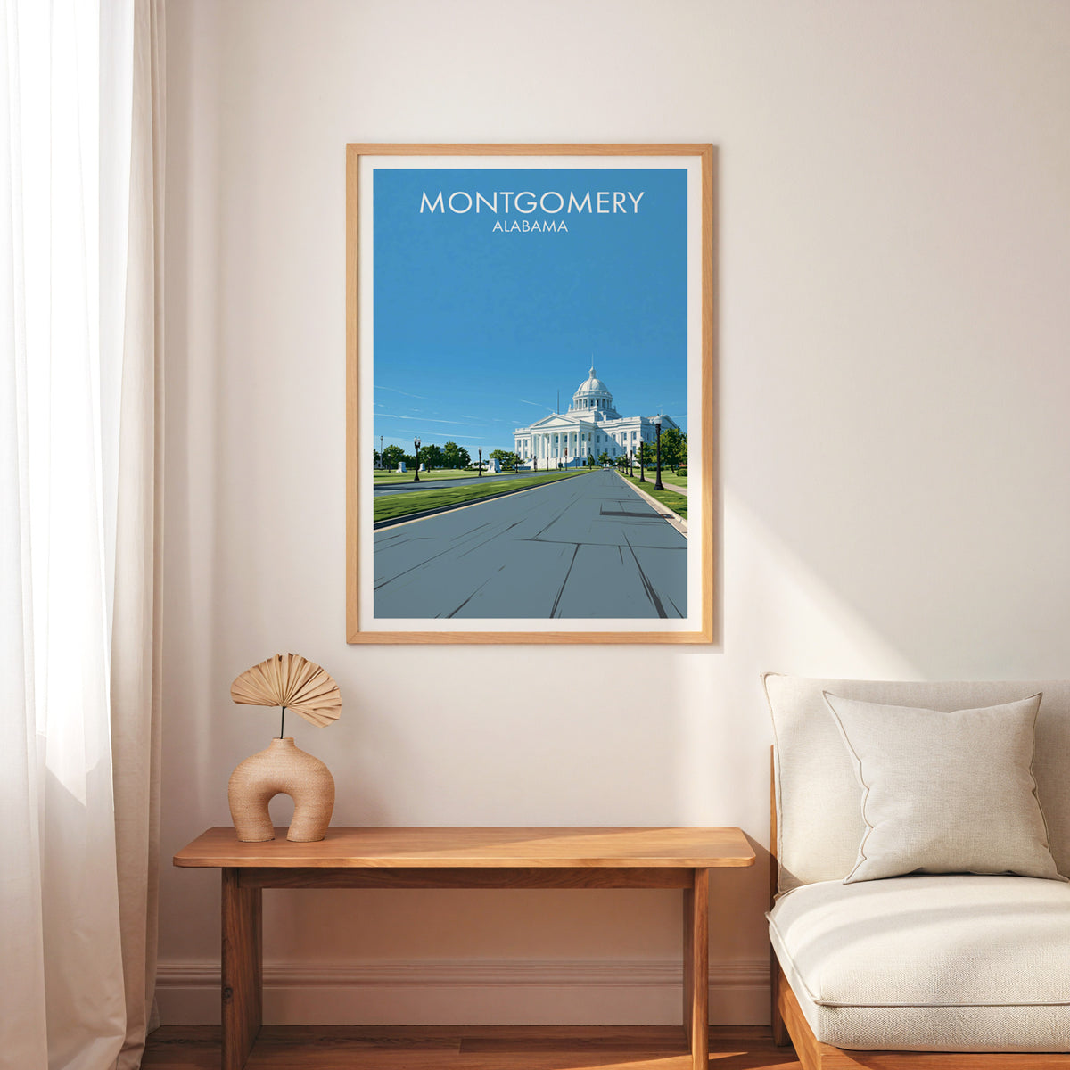 Alabama capitol dome print in an oak frame above a slim wood bench, cream armchair and linen curtain