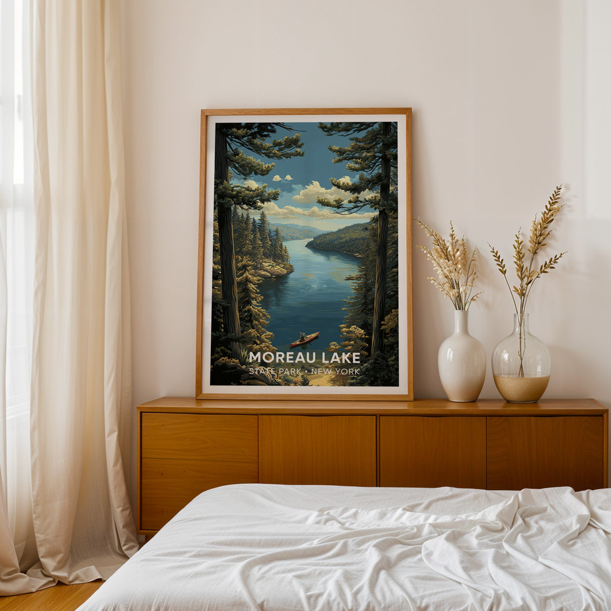 Moreau Lake print in an oak frame on a teak sideboard by a bed, dried pampas in two white vases
