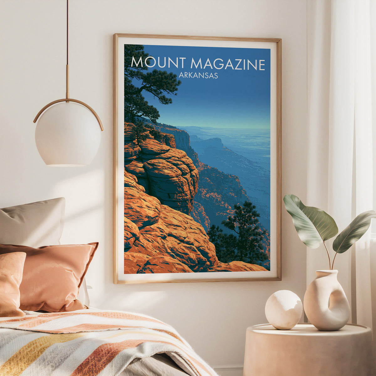 Large oak-framed Mount Magazine print above a rust linen bed with a brass pendant lamp and cream side table
