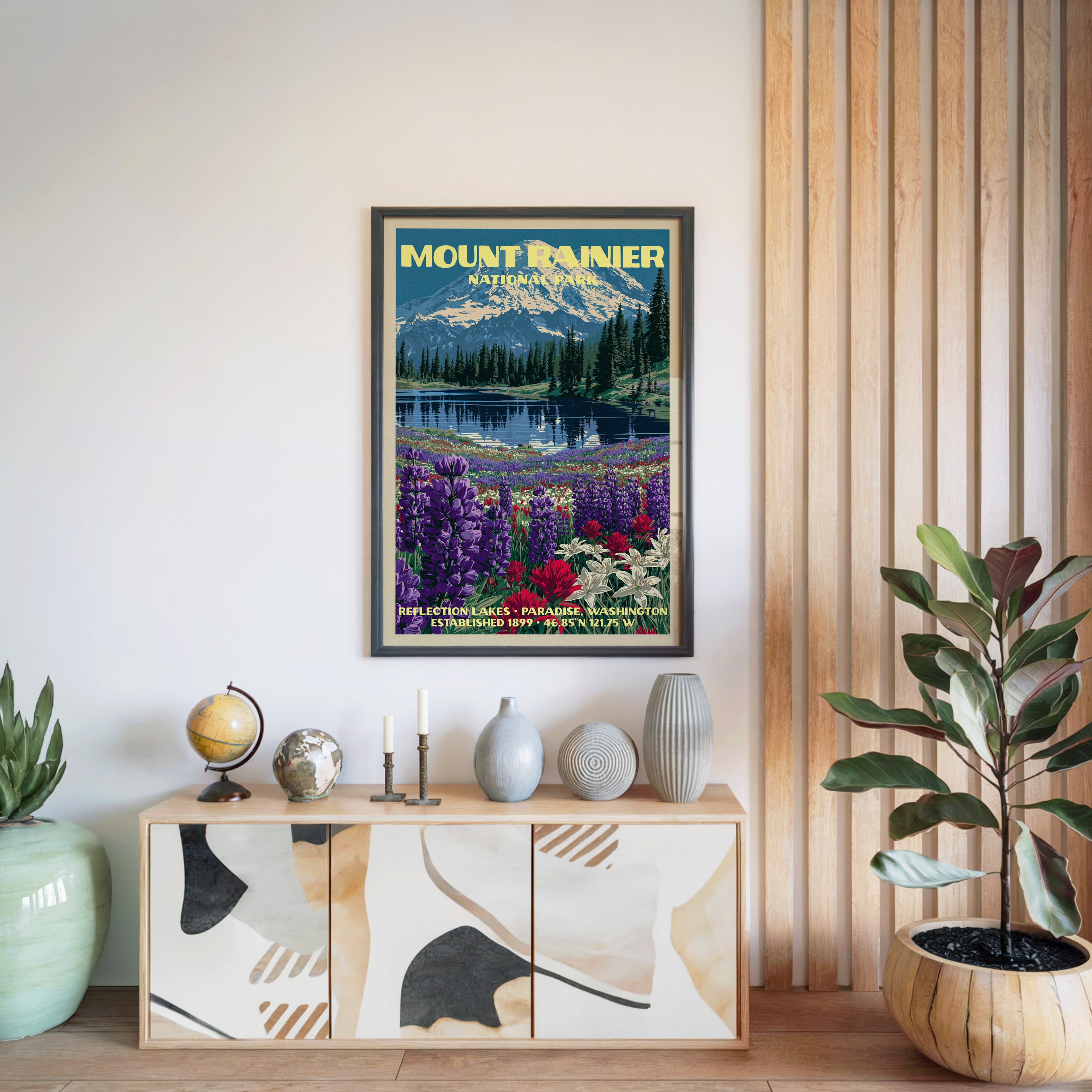 Mount Rainier National Park poster in a black frame above a light wood sideboard by a slatted wall panel