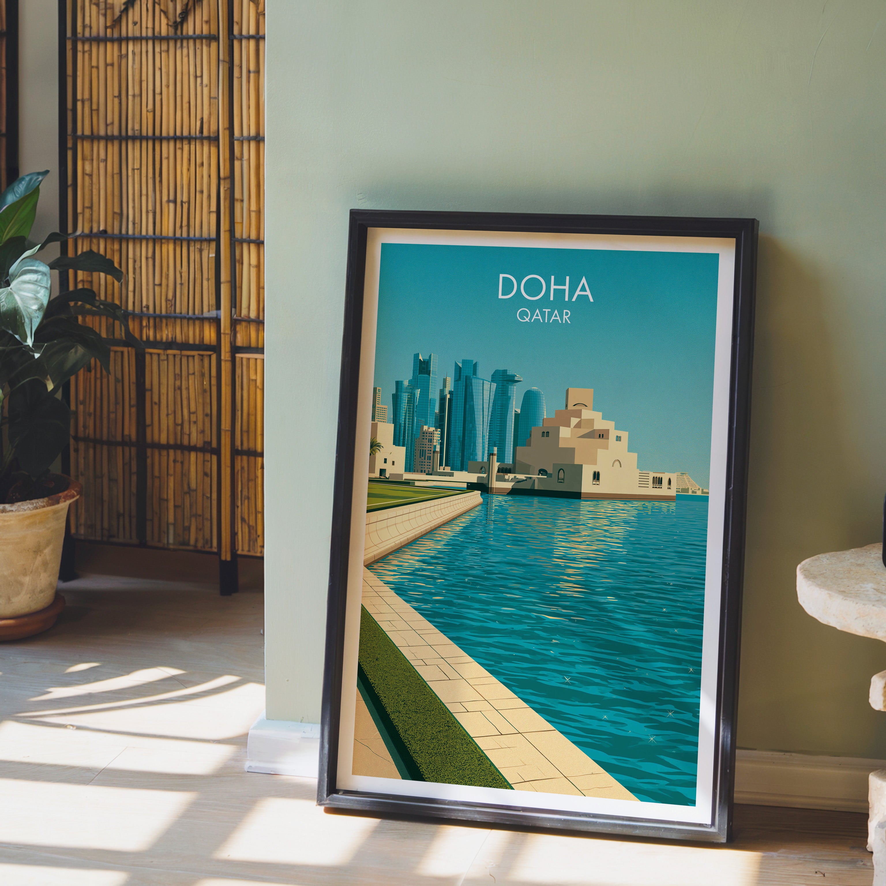 Doha Qatar wall art in a black frame leaning against a sage green wall beside a bamboo screen