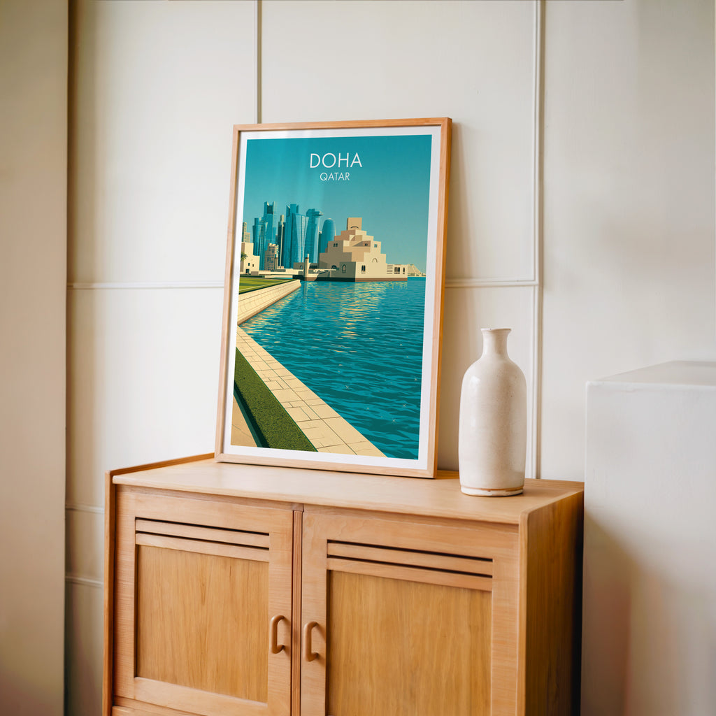 Small Doha Qatar travel poster in an oak frame on a mid-century sideboard with a ceramic vase