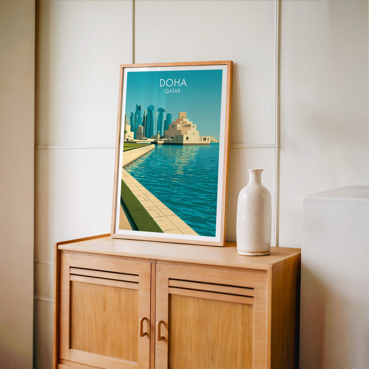 Museum of Islamic Art Doha poster in an oak frame standing on a light oak cabinet against a cream panelled wall