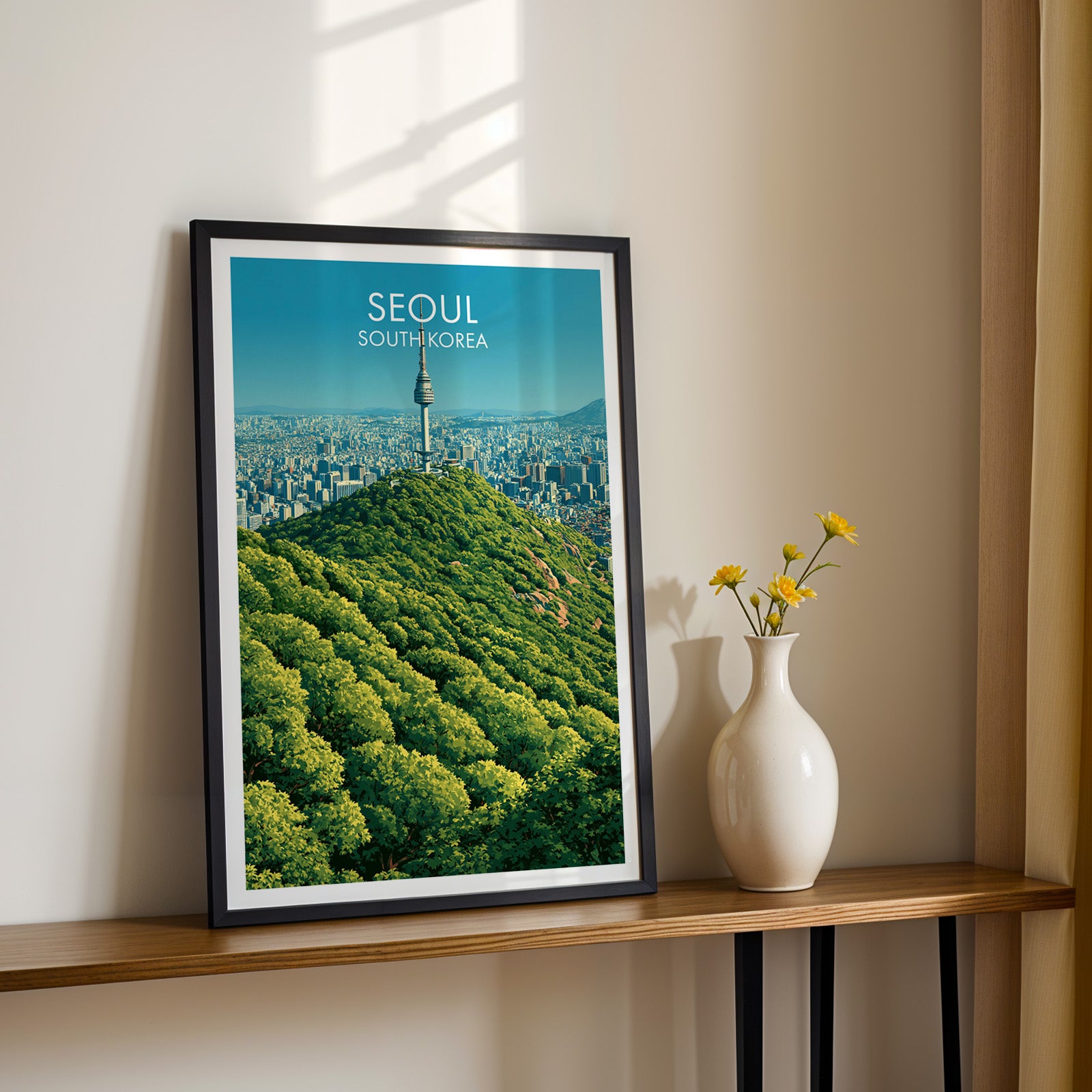 Black framed N Seoul Tower Seoul Korea print on a narrow hallway console in sunlight, styled with yellow flowers
