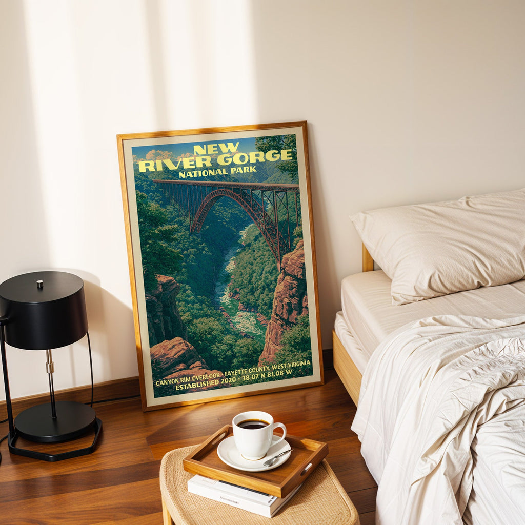 Canyon Rim Overlook New River Gorge poster in a gold frame on the floor beside a made bed and a black lamp