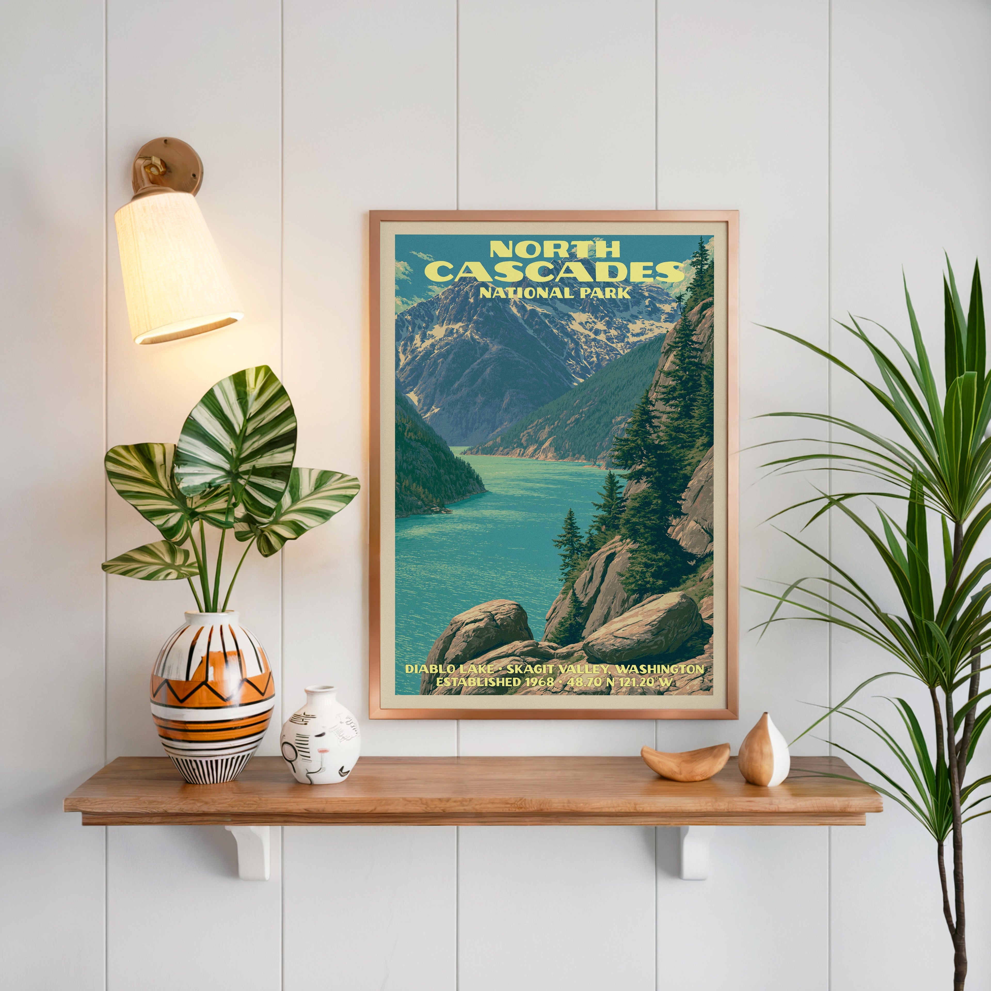 Diablo Lake North Cascades print framed on white panelling above an oak shelf with a patterned vase and sconce