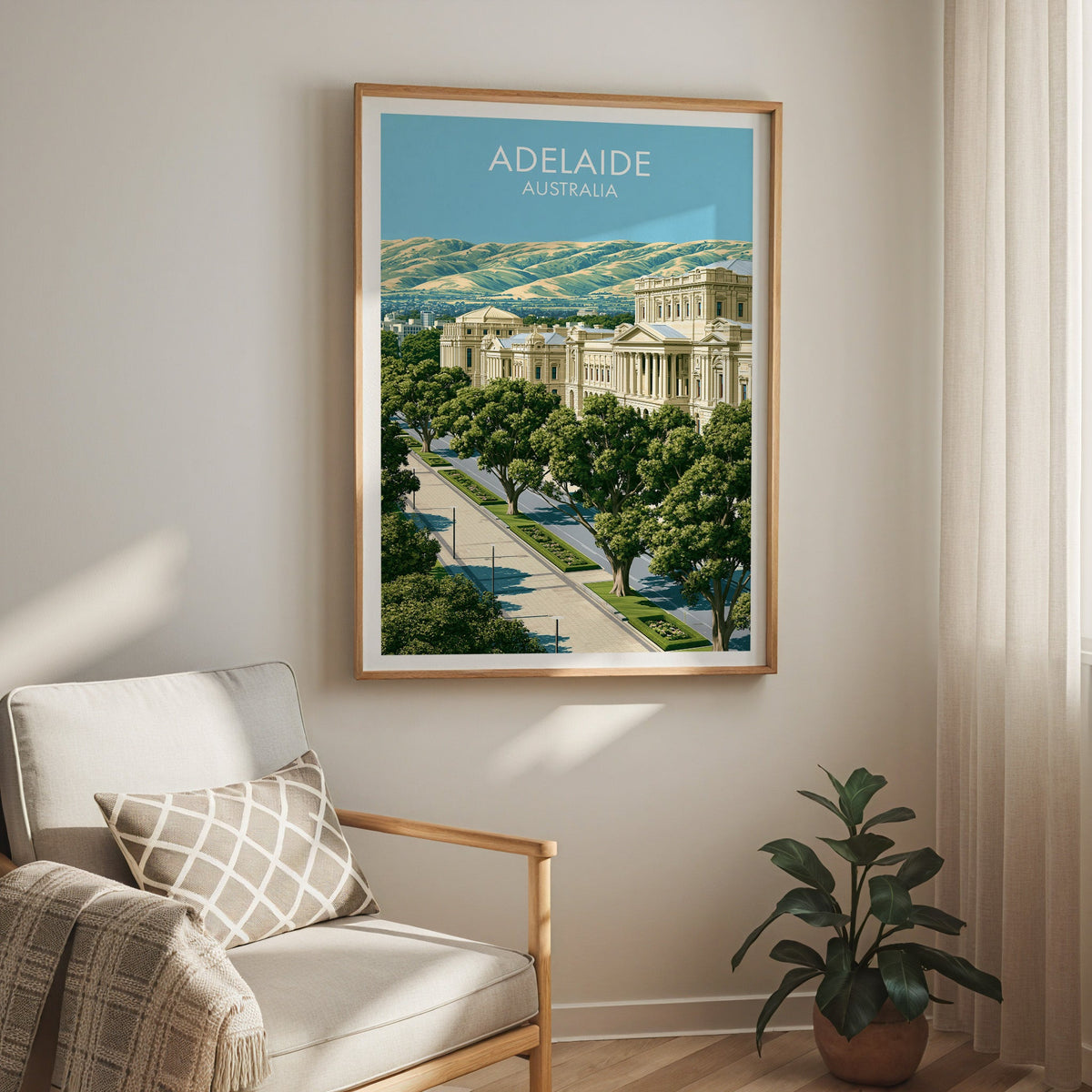North Terrace print in an oak frame above a cream armchair with a sheer curtain and a rubber plant