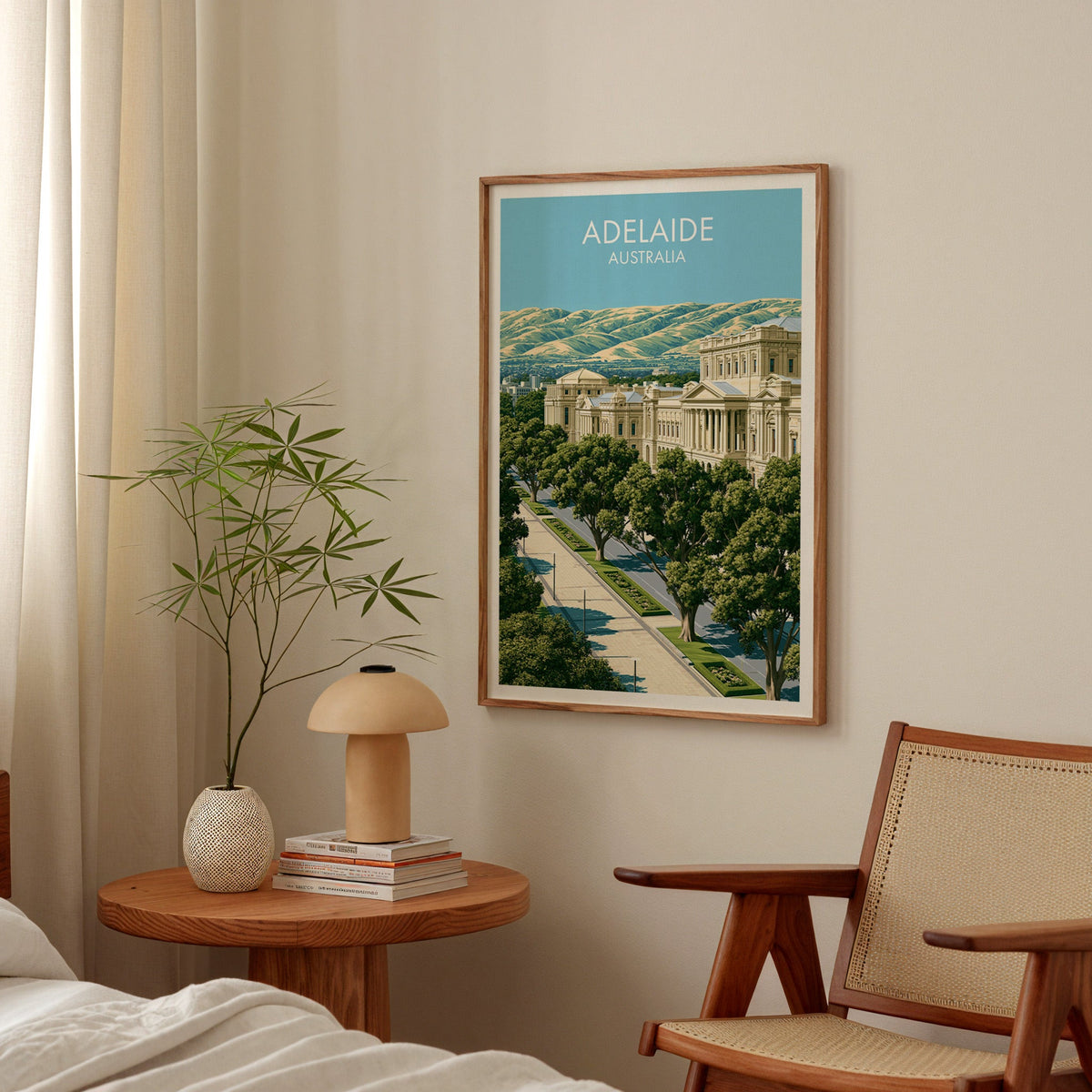 Adelaide bedroom print in an oak frame above a round bedside table with a mushroom lamp and bamboo