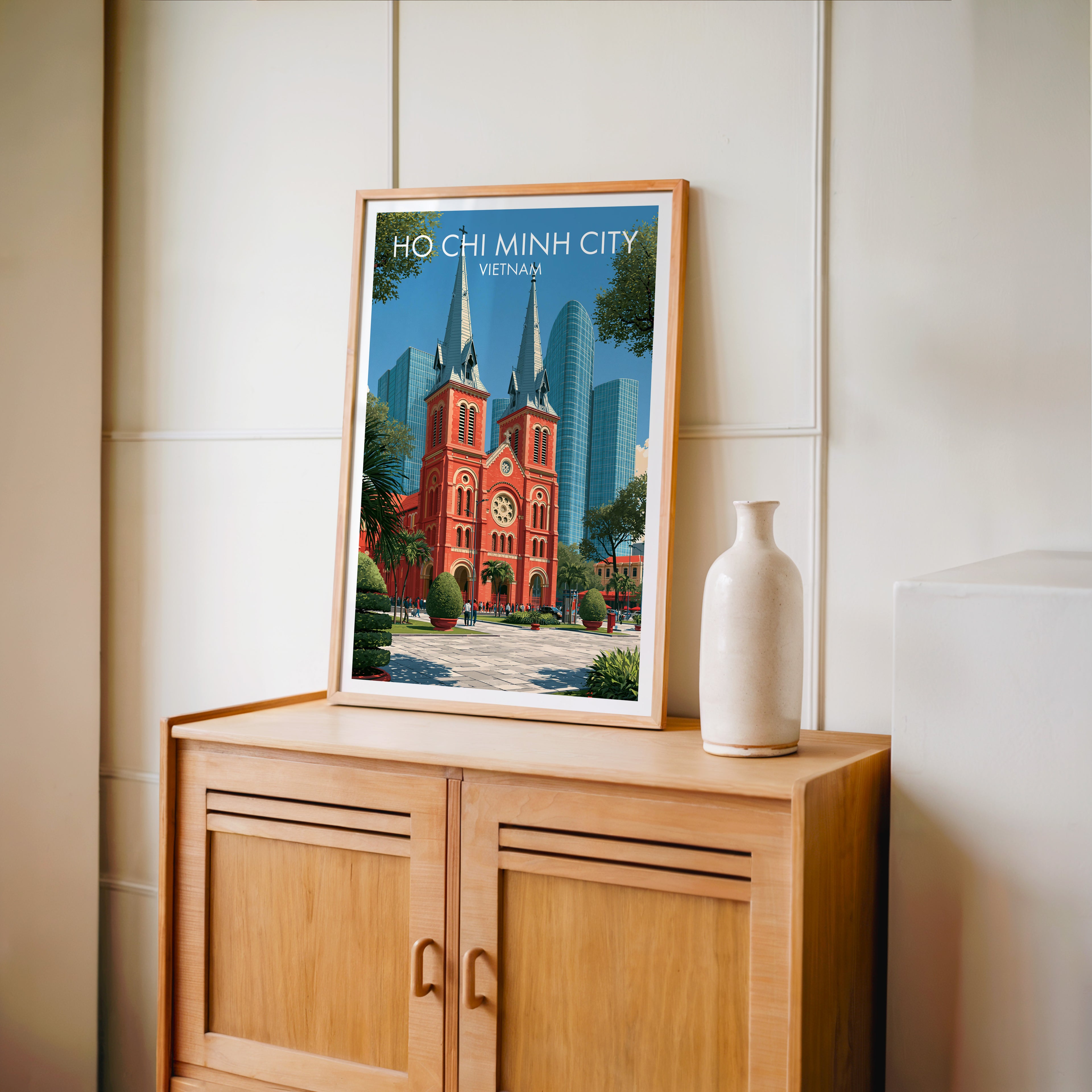Small Ho Chi Minh City Vietnam travel poster in an oak frame on a mid-century sideboard with a ceramic vase