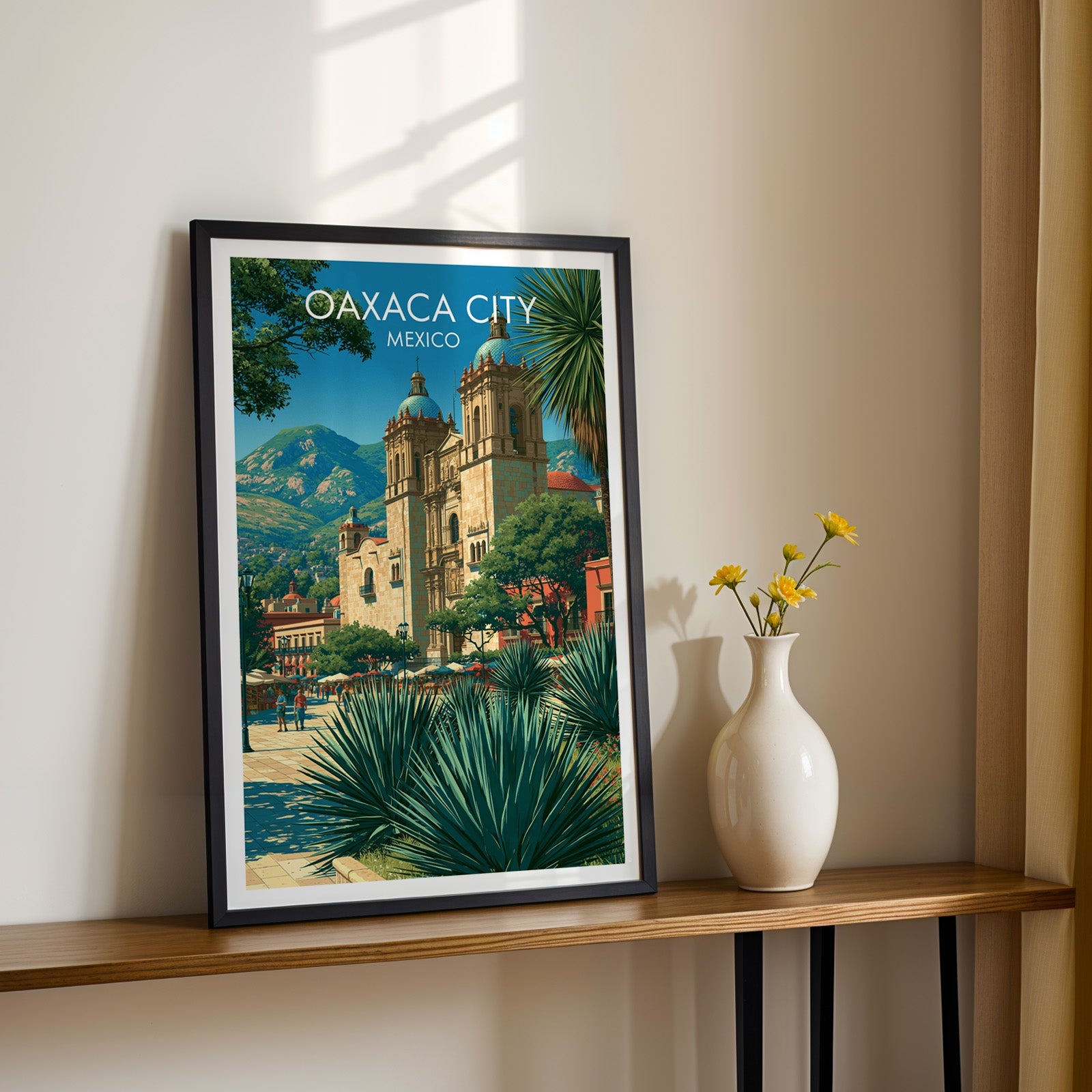 Agave spears and honey stone facade, black frame on a wood shelf with yellow daisies on a cream wall