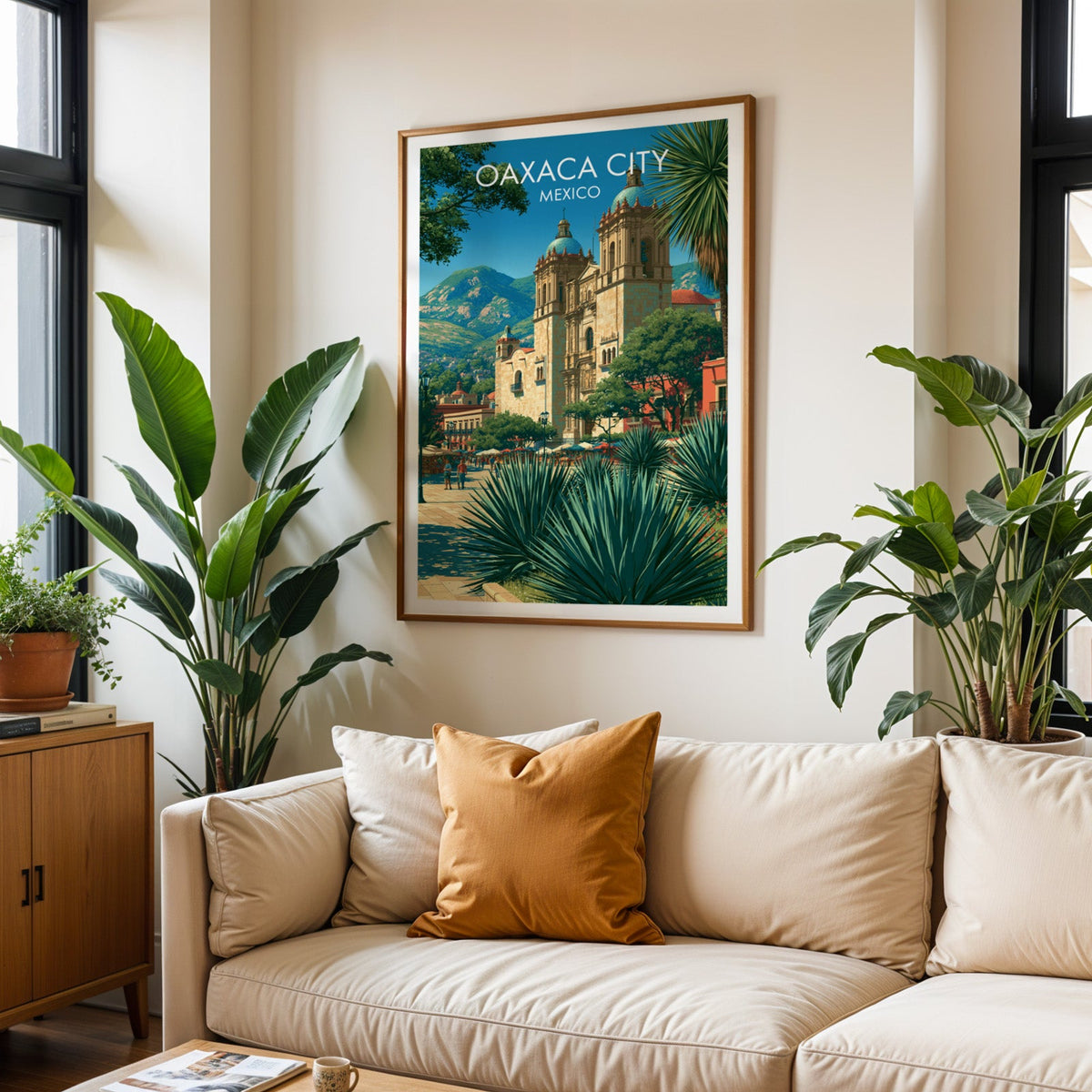 Oaxaca travel print in an oak frame above a cream sofa with a burnt-orange cushion and tropical plants