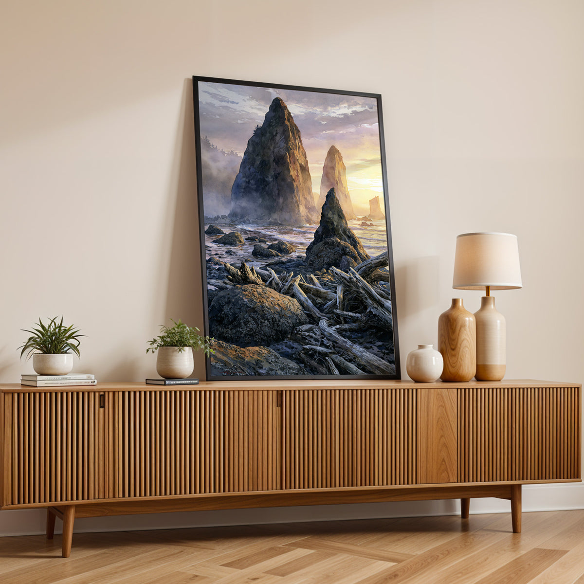 Olympic National Park watercolor print in a black frame on a fluted wood sideboard with a lamp and small plants