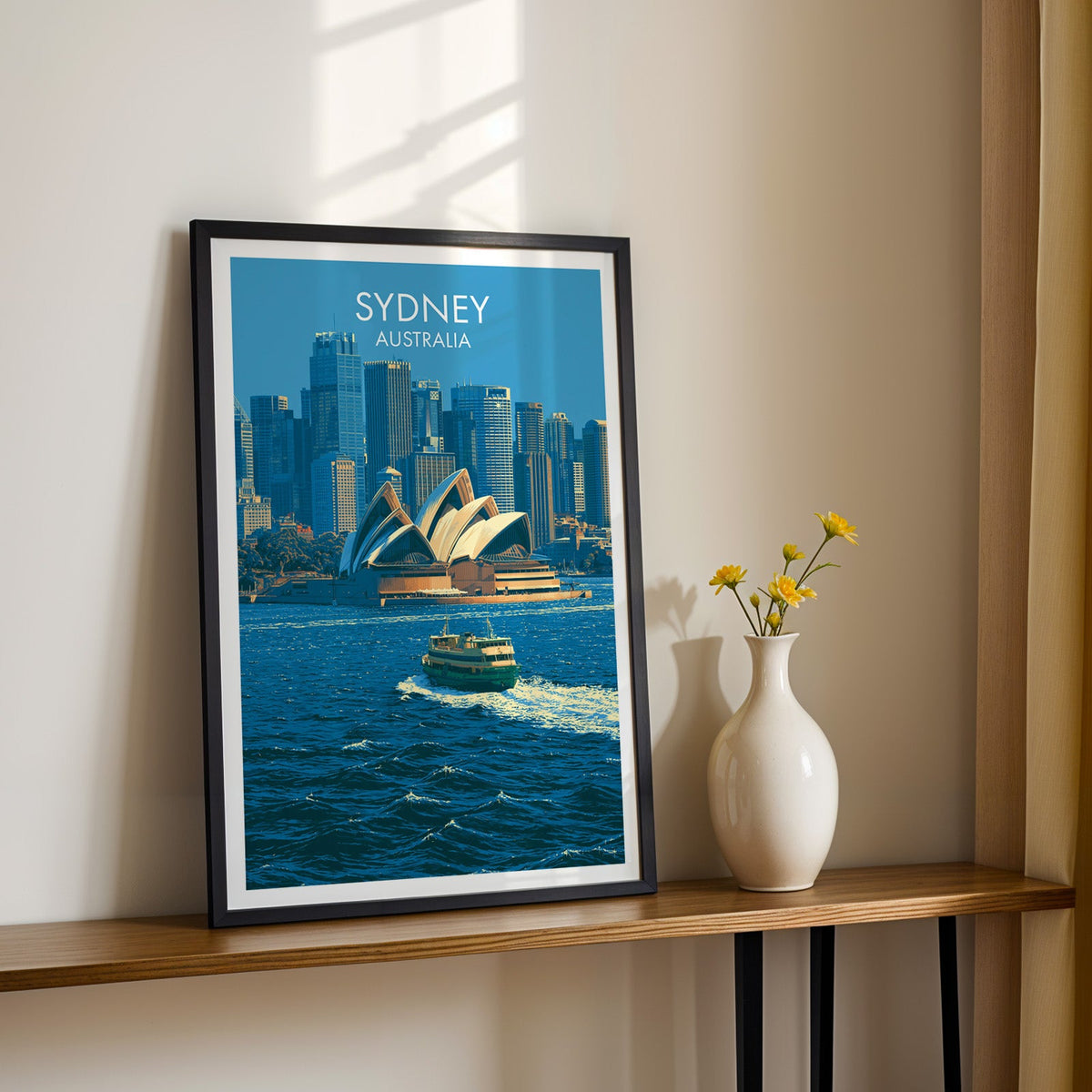 Opera House shell roofs print in a black frame on a wood shelf with yellow daisies on a cream wall