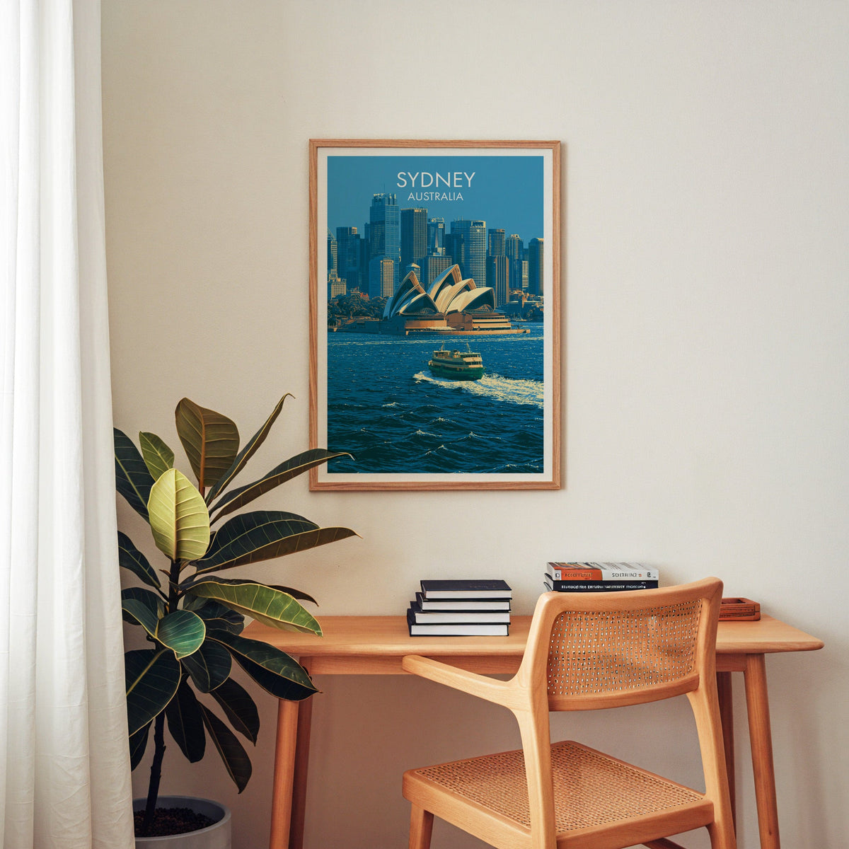 Opera House wall art in an oak frame above a wooden home-office desk with a cane chair and plant